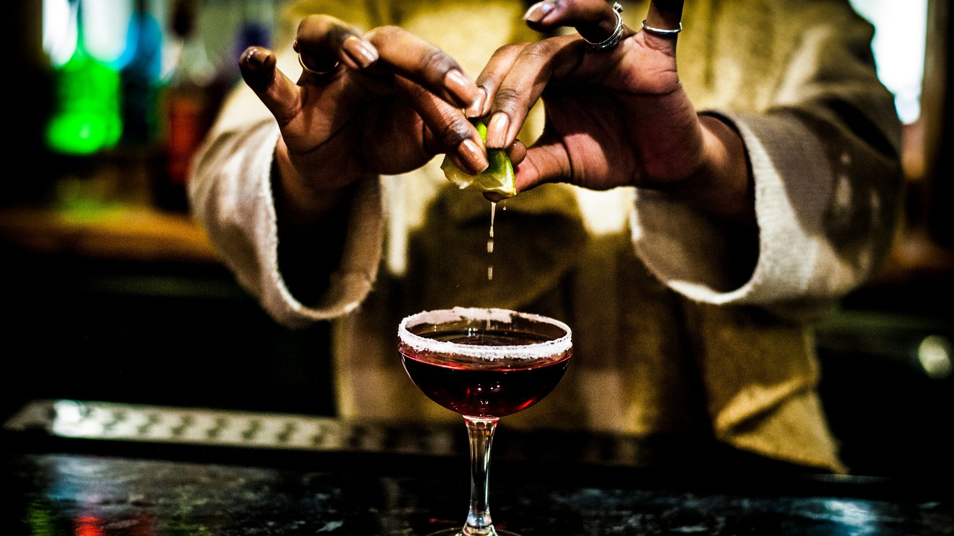 person holding clear wine glass with red wine