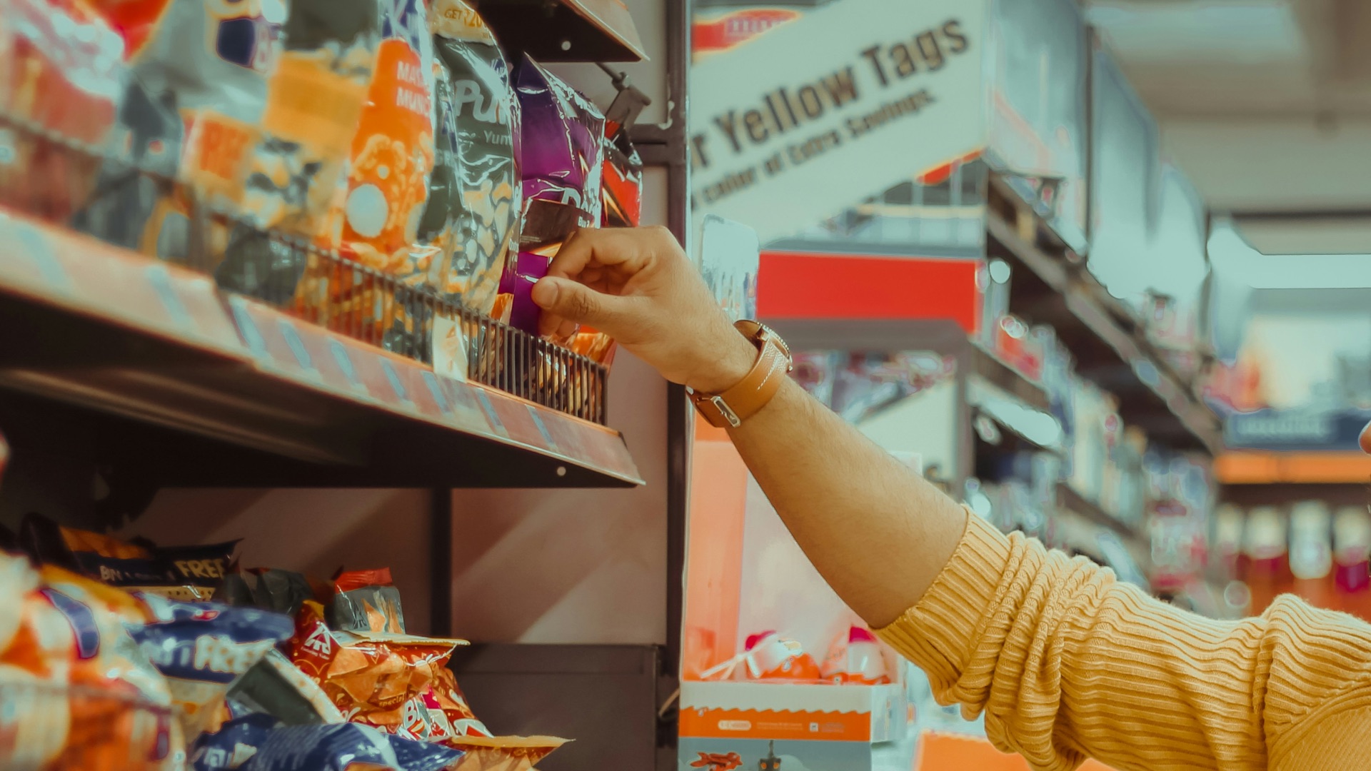 woman in yellow sweater holding red and white box