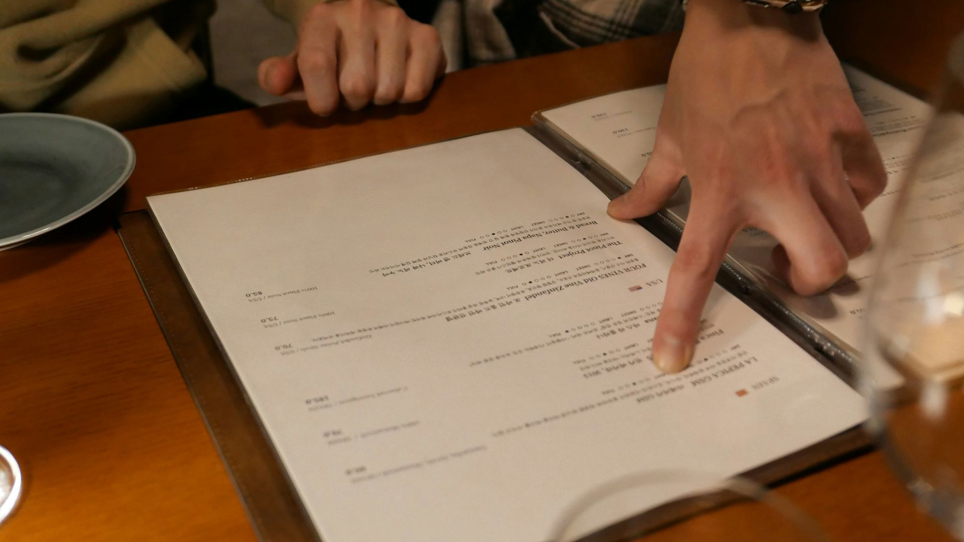 two people sitting at a table with a menu in front of them