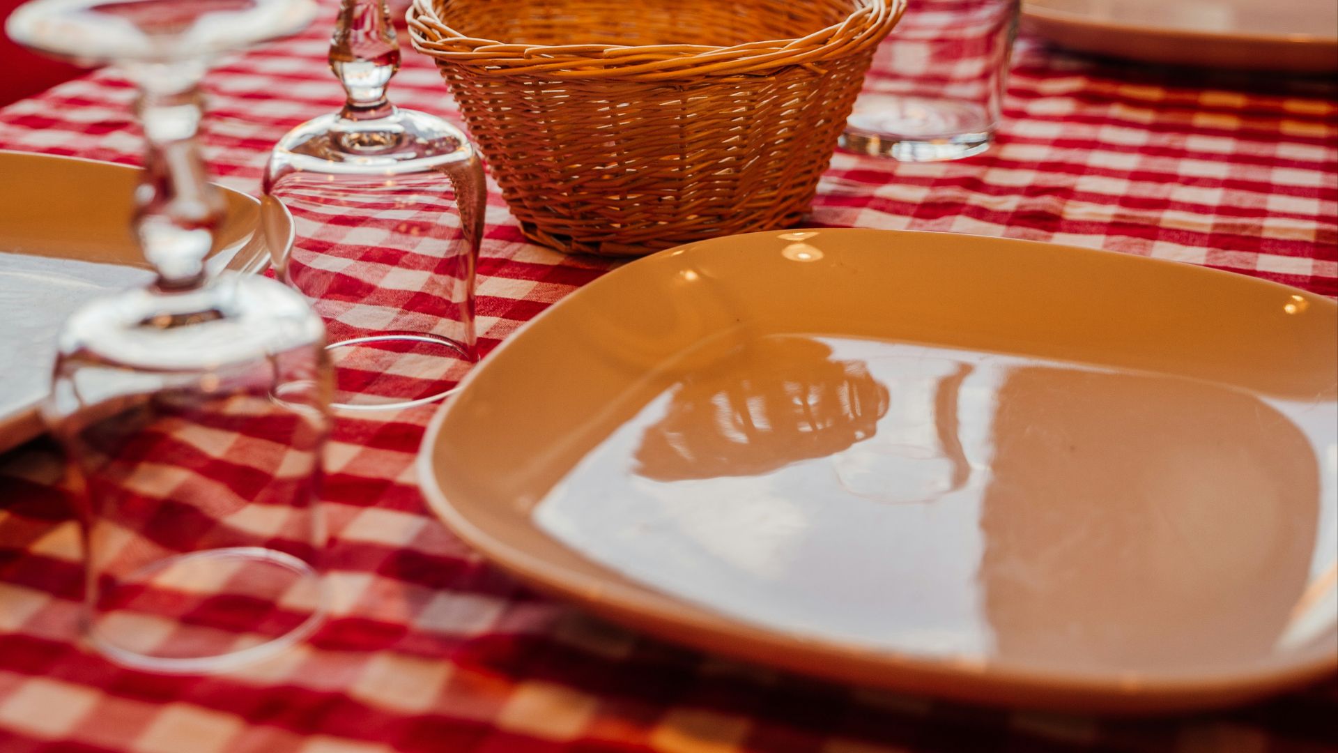 a red and white checkered table cloth with wine glasses