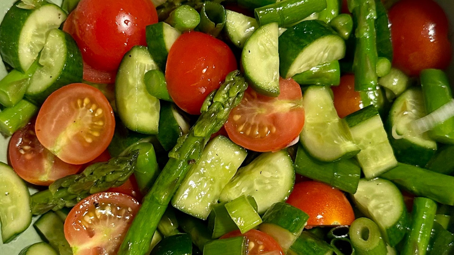 Fresh salad with tomatoes, cucumber, and asparagus.