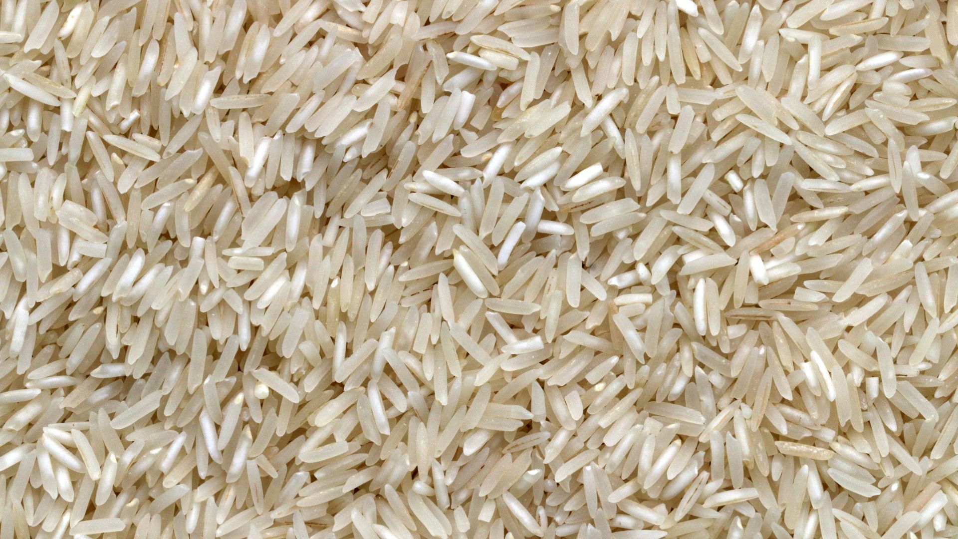 white rice grains on brown wooden table