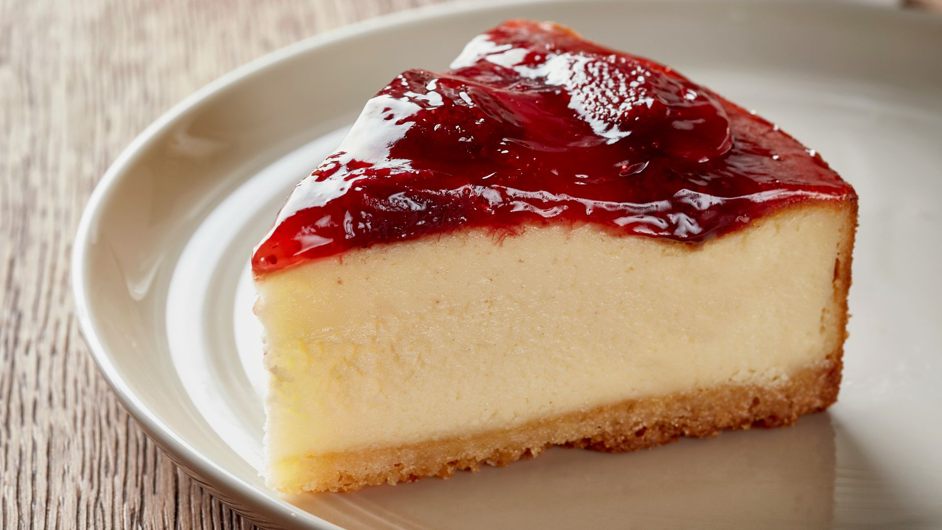 a piece of cheesecake on a plate next to a cup of coffee