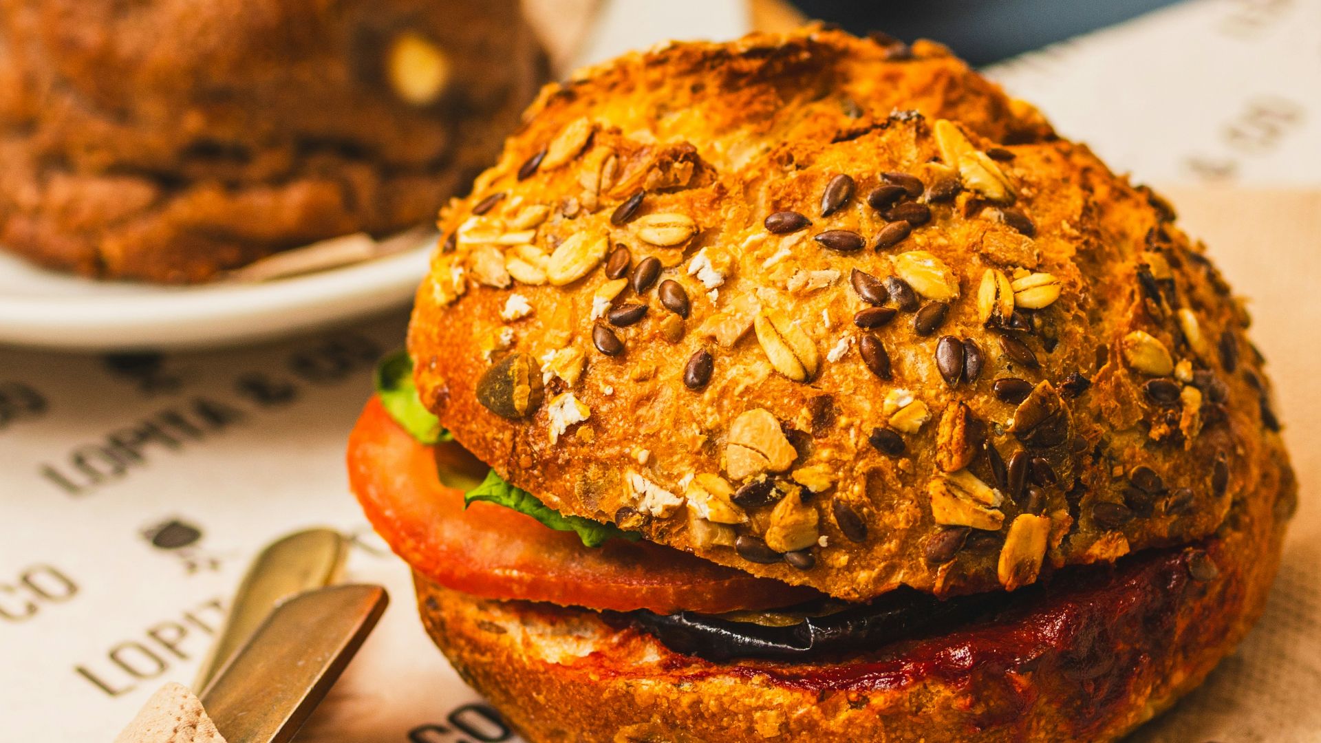 A delicious sandwich with seeded bun and tomato.