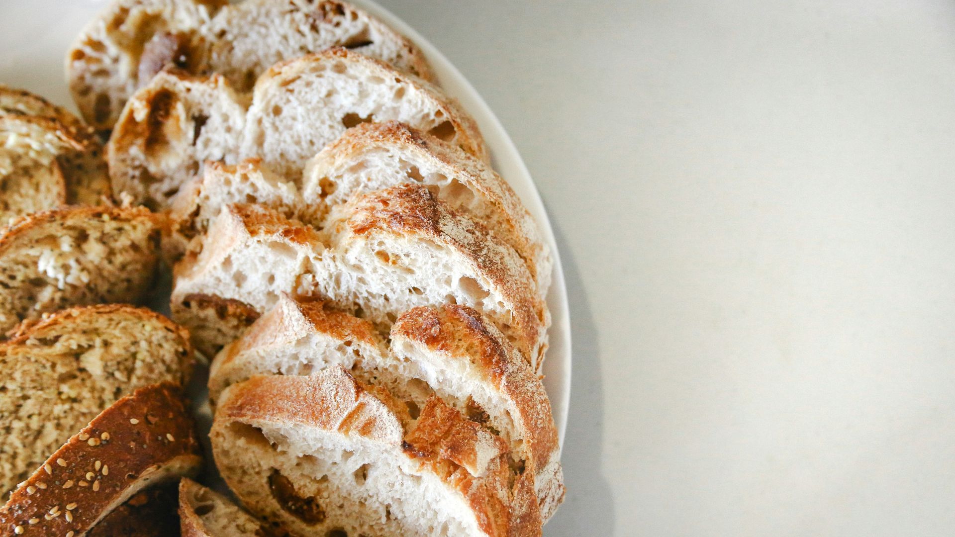 a white plate topped with sliced bread on top of a table