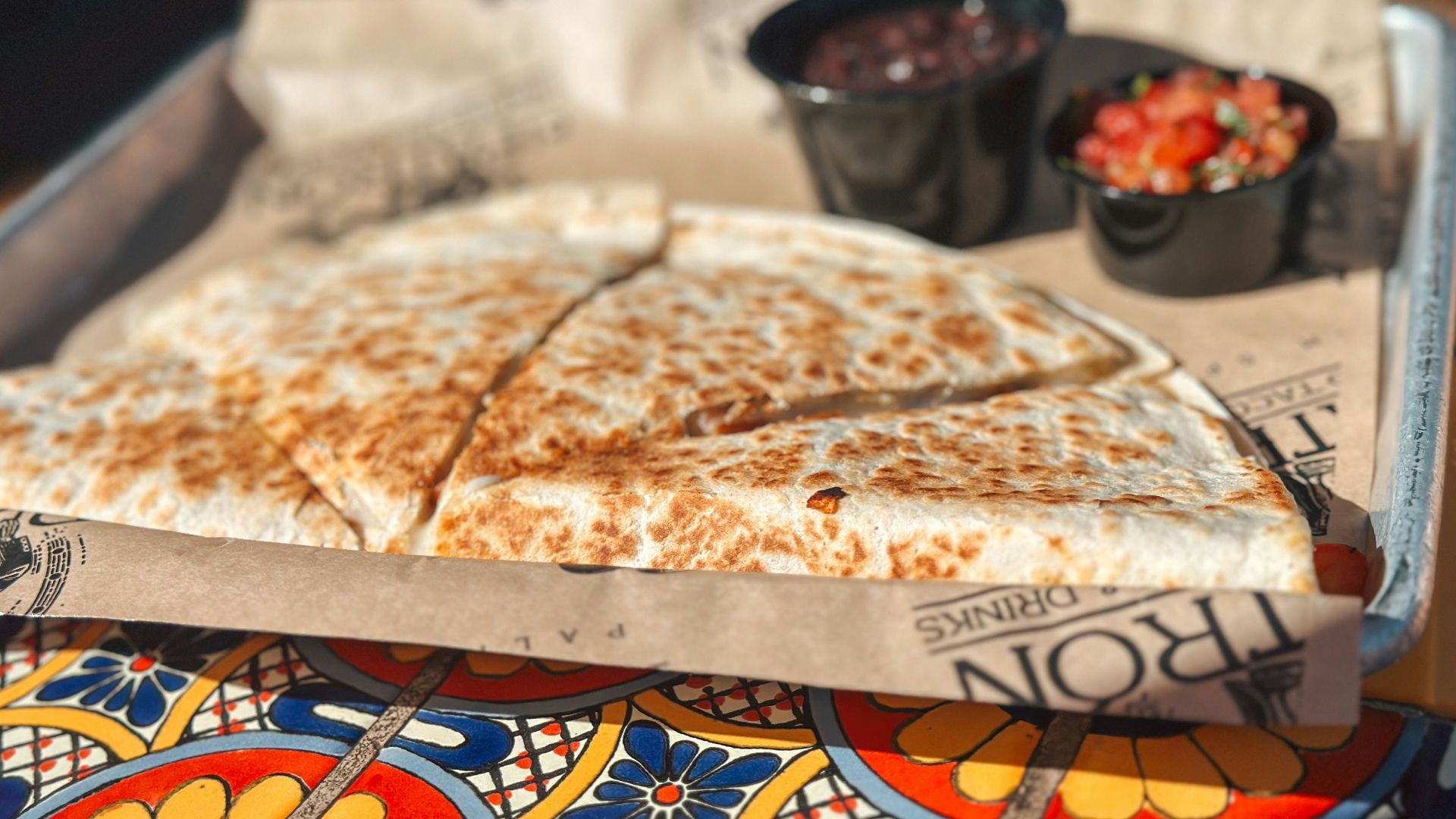 a tray of food on a table with a bowl of salsa