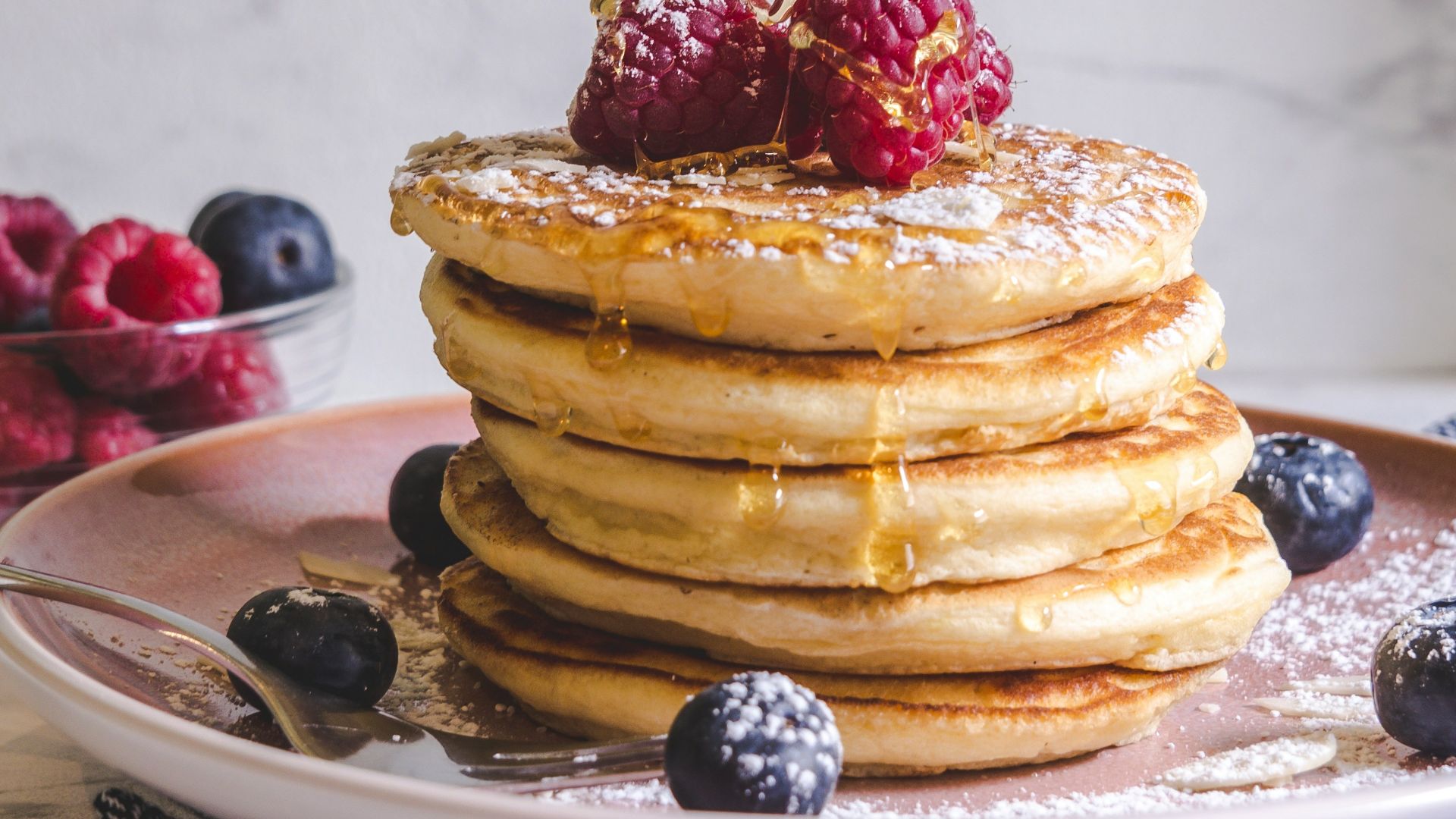 pancakes with berries on white ceramic plate