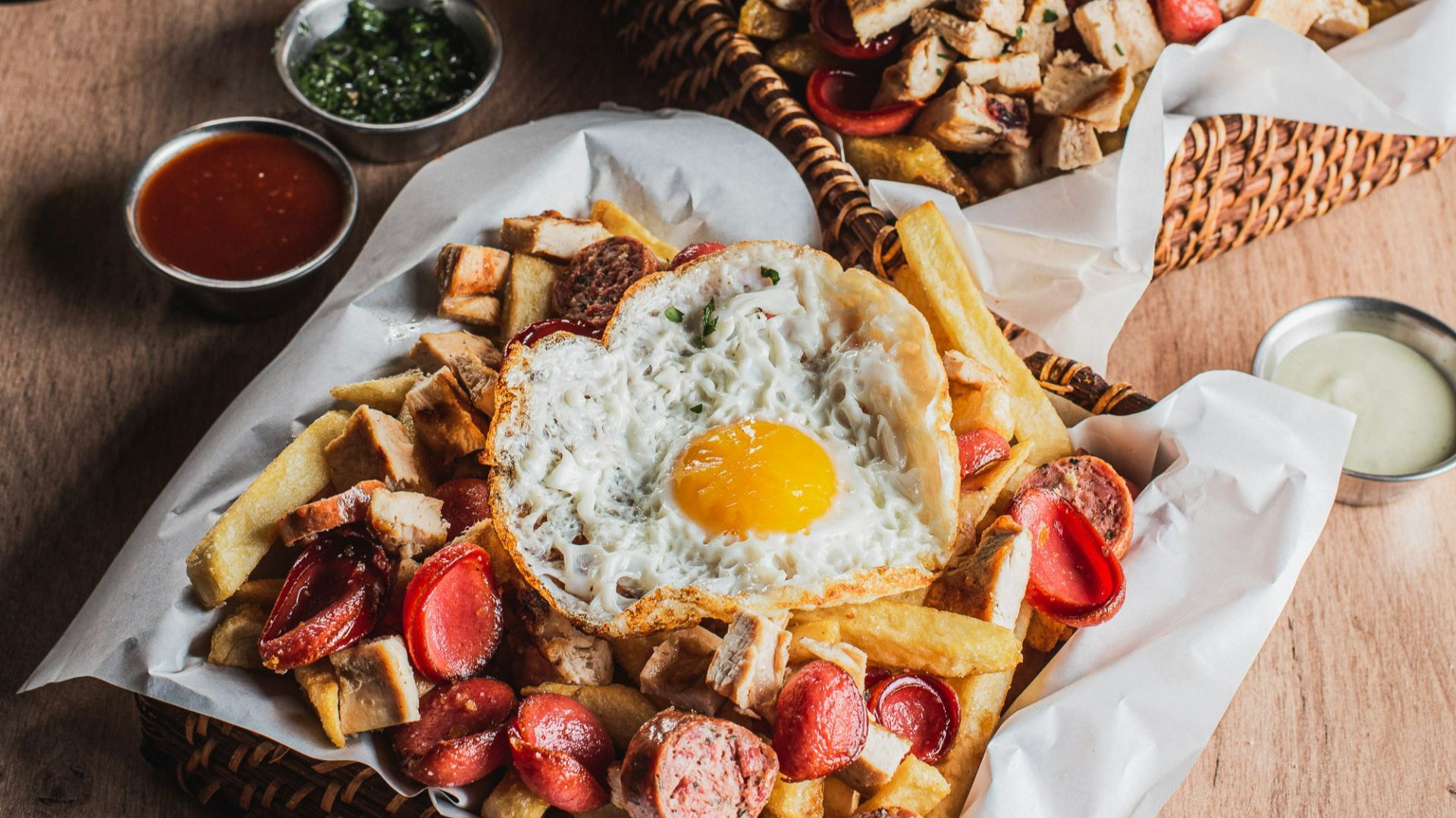 Hearty meal with fries, eggs, sausages, and burgers.