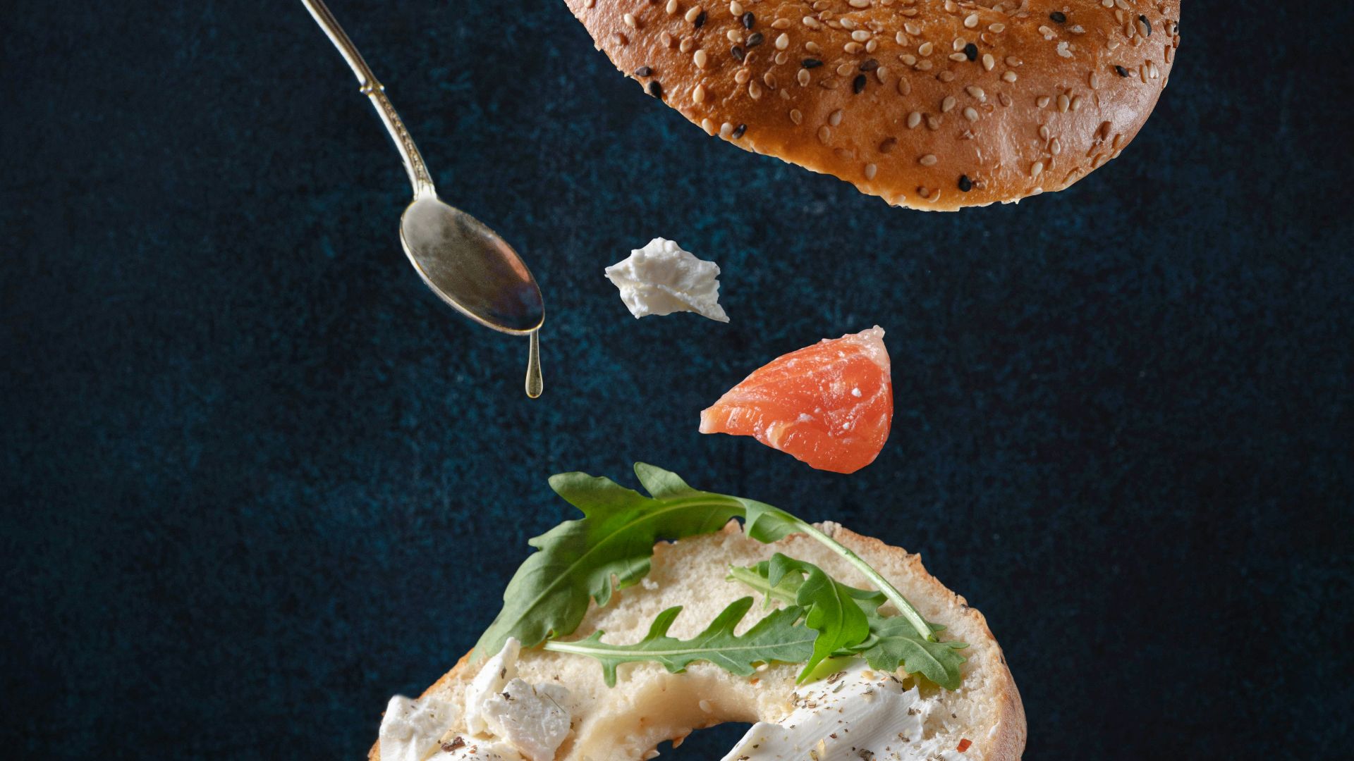 bread with sliced tomato and green vegetable on black textile