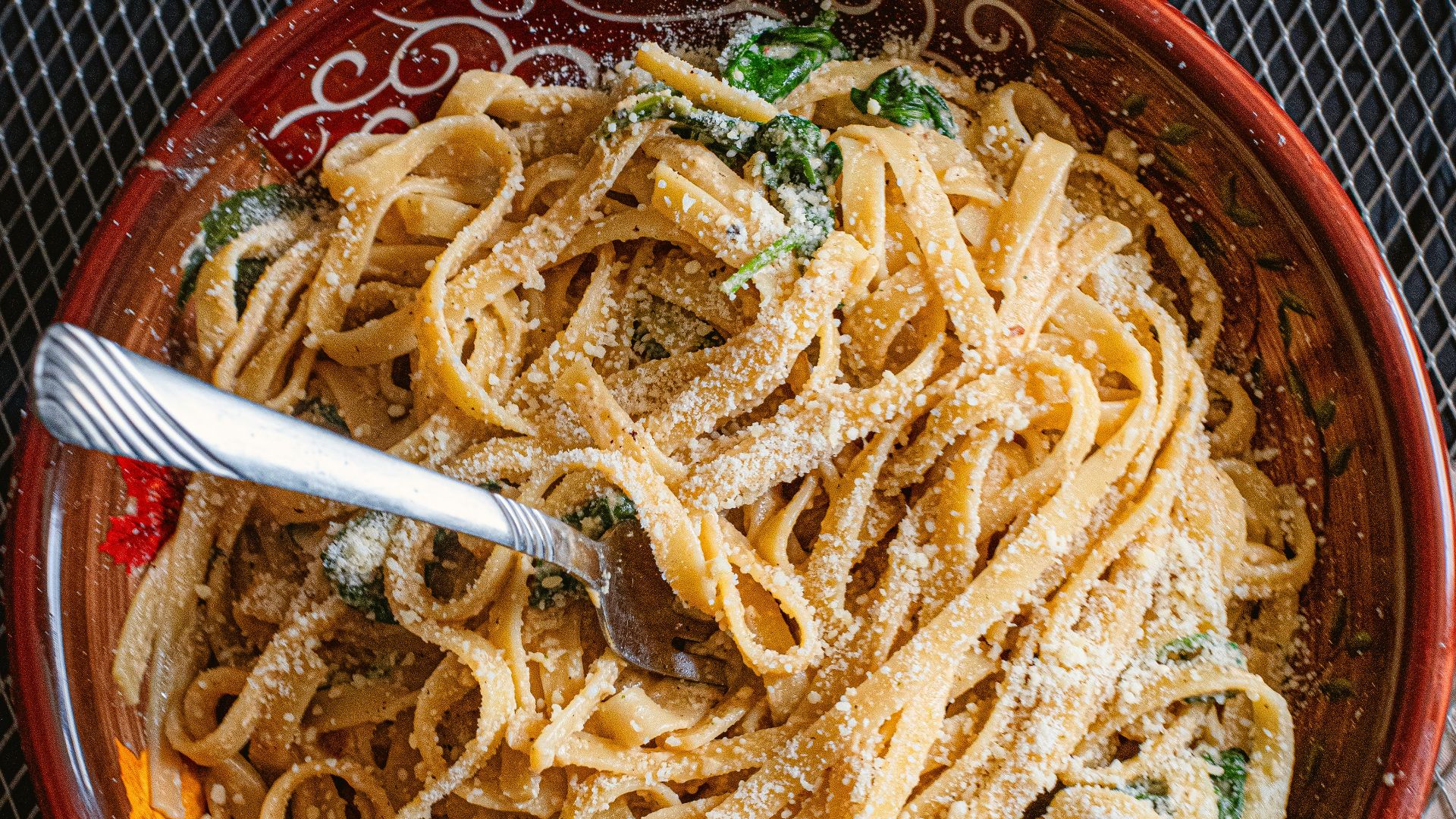 A bowl of pasta with a fork in it