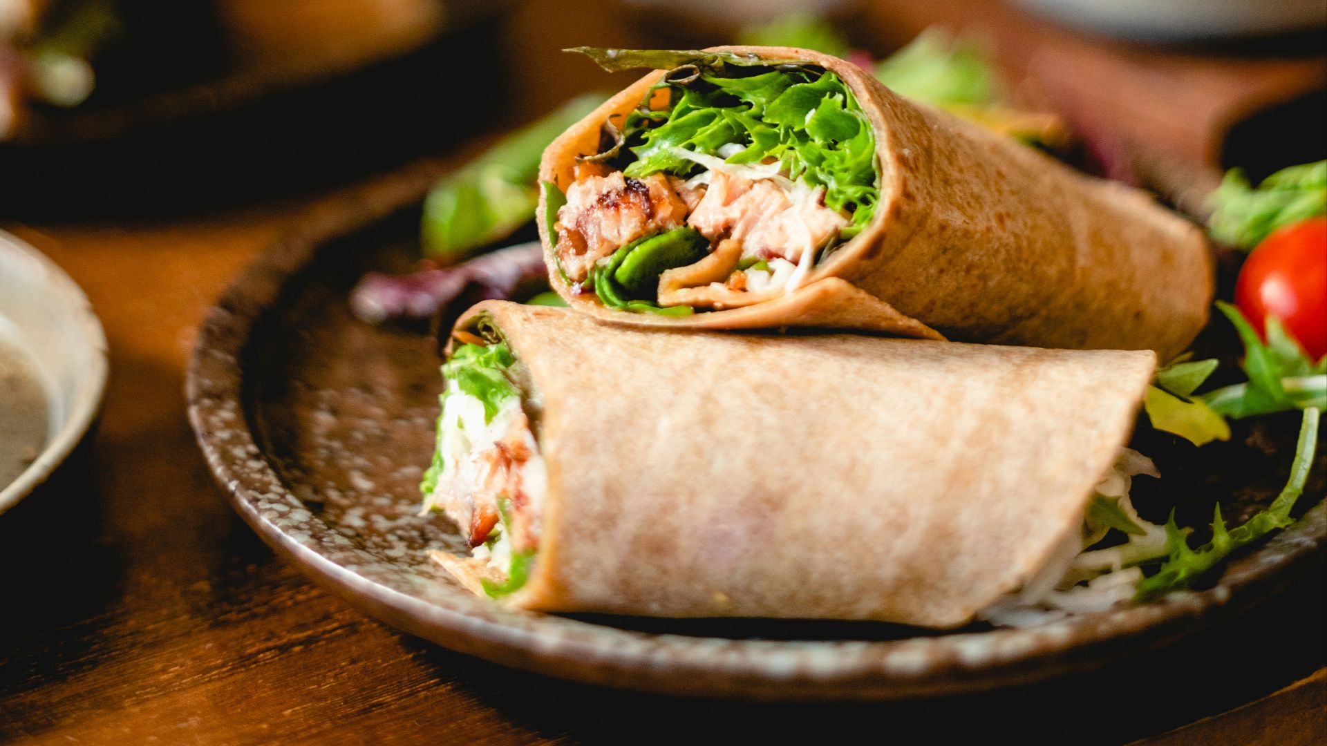 a plate with a burrito and salad on it