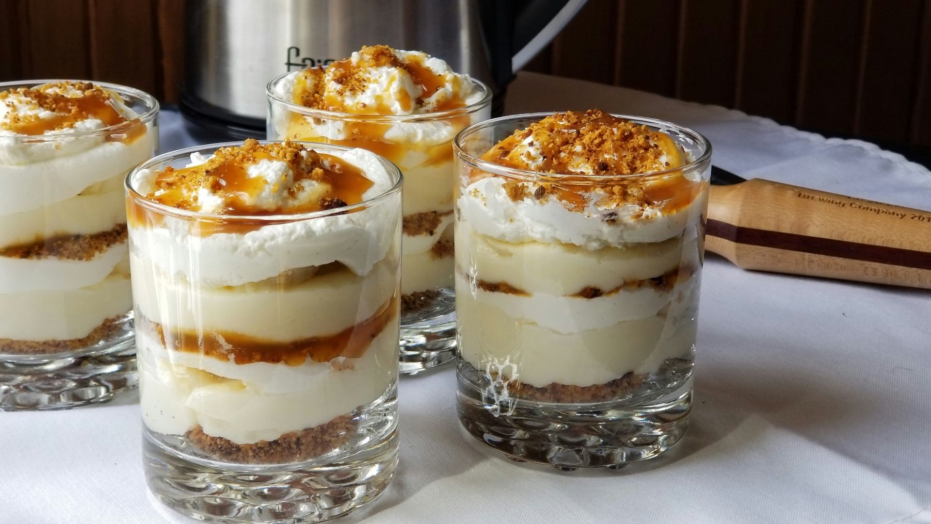 four desserts sitting on a table with a crock pot in the background