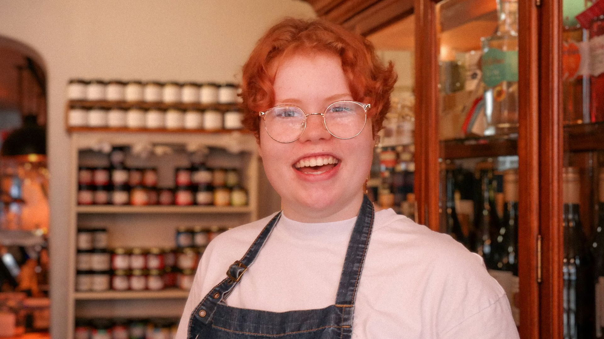 a woman wearing glasses and an apron in a store