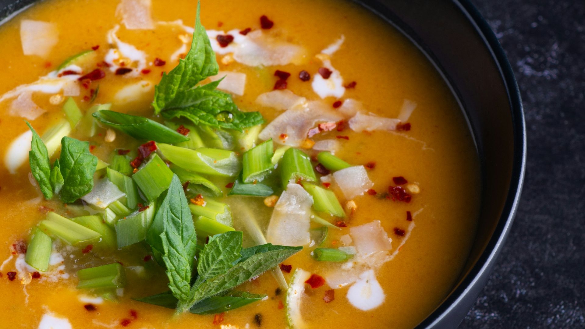 soup with green leaf on black ceramic bowl