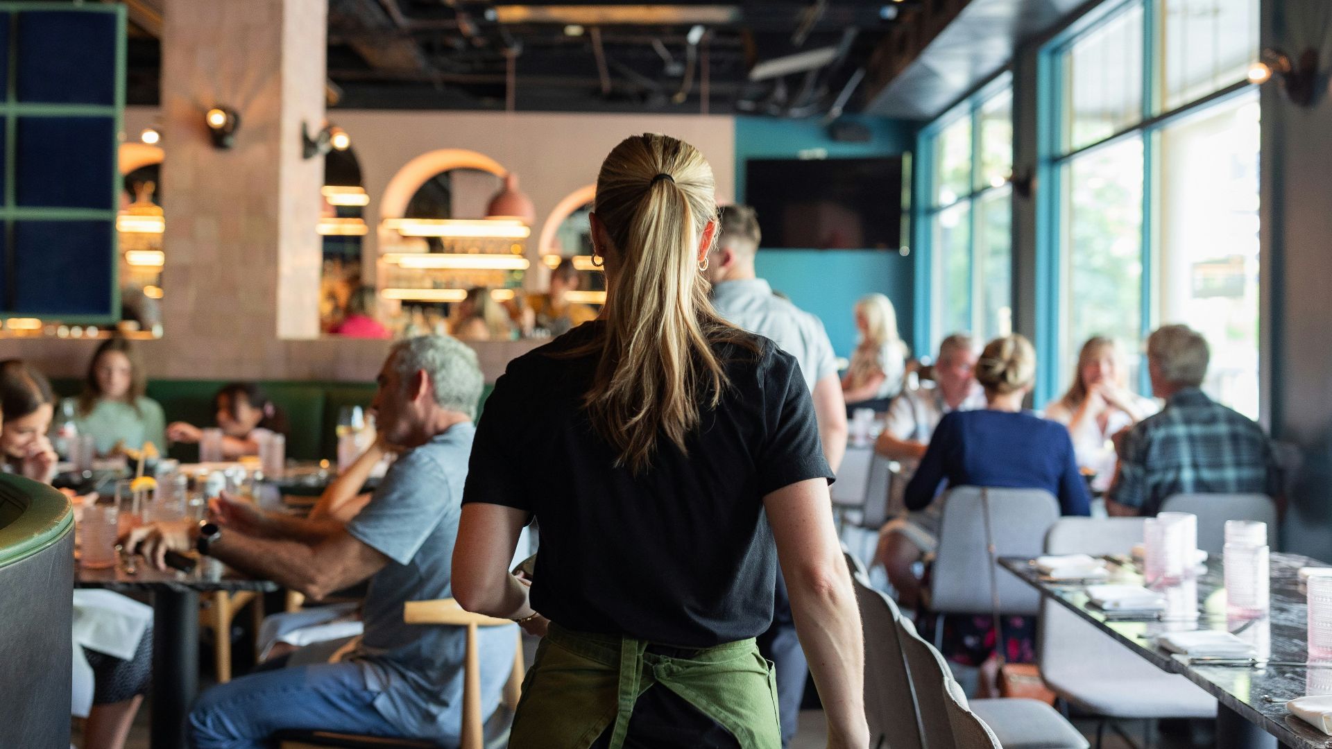 A group of people sitting at tables in a restaurant