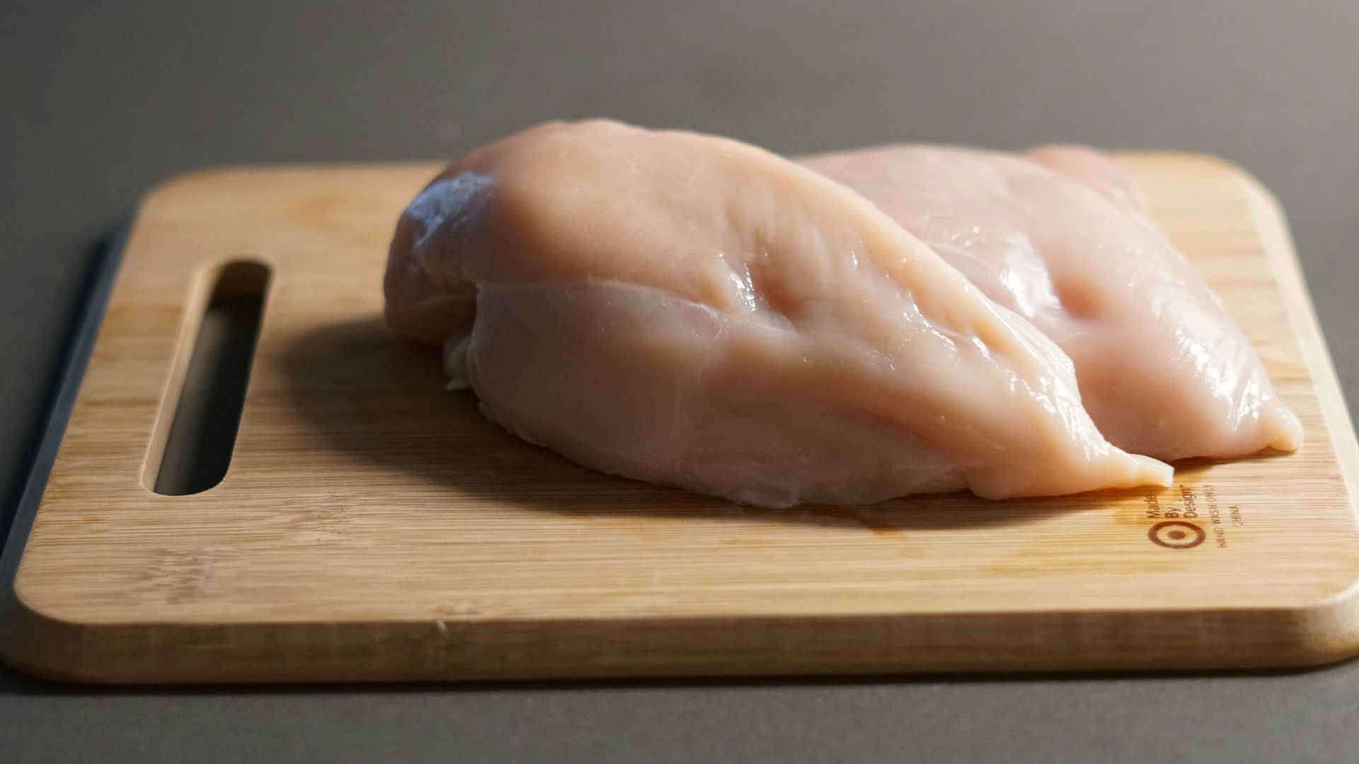 a piece of raw chicken on a cutting board