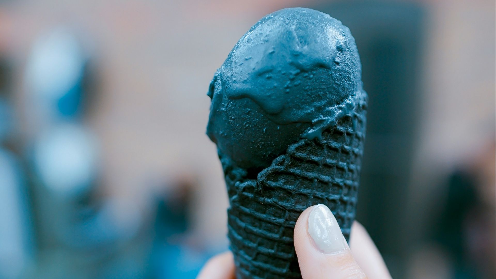 person holding black ice cream