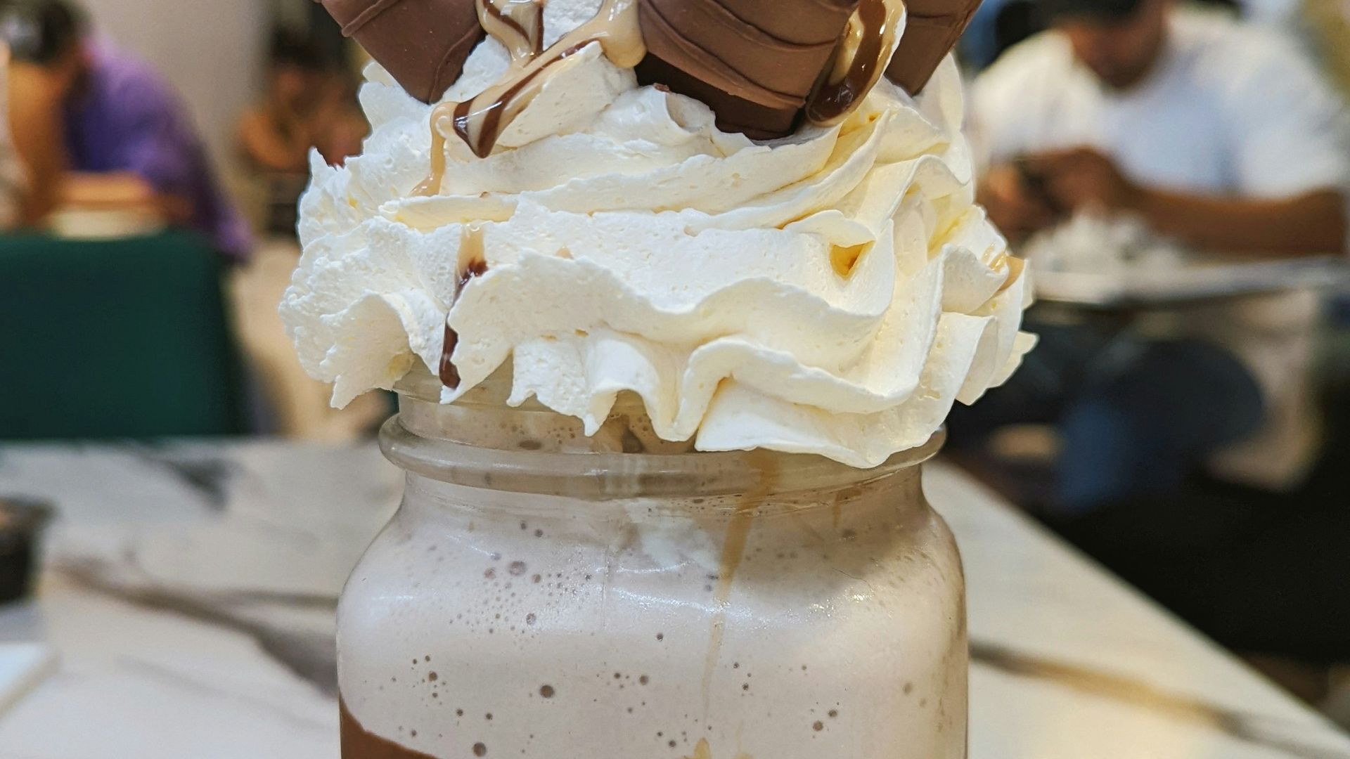 a glass jar filled with whipped cream and chocolate