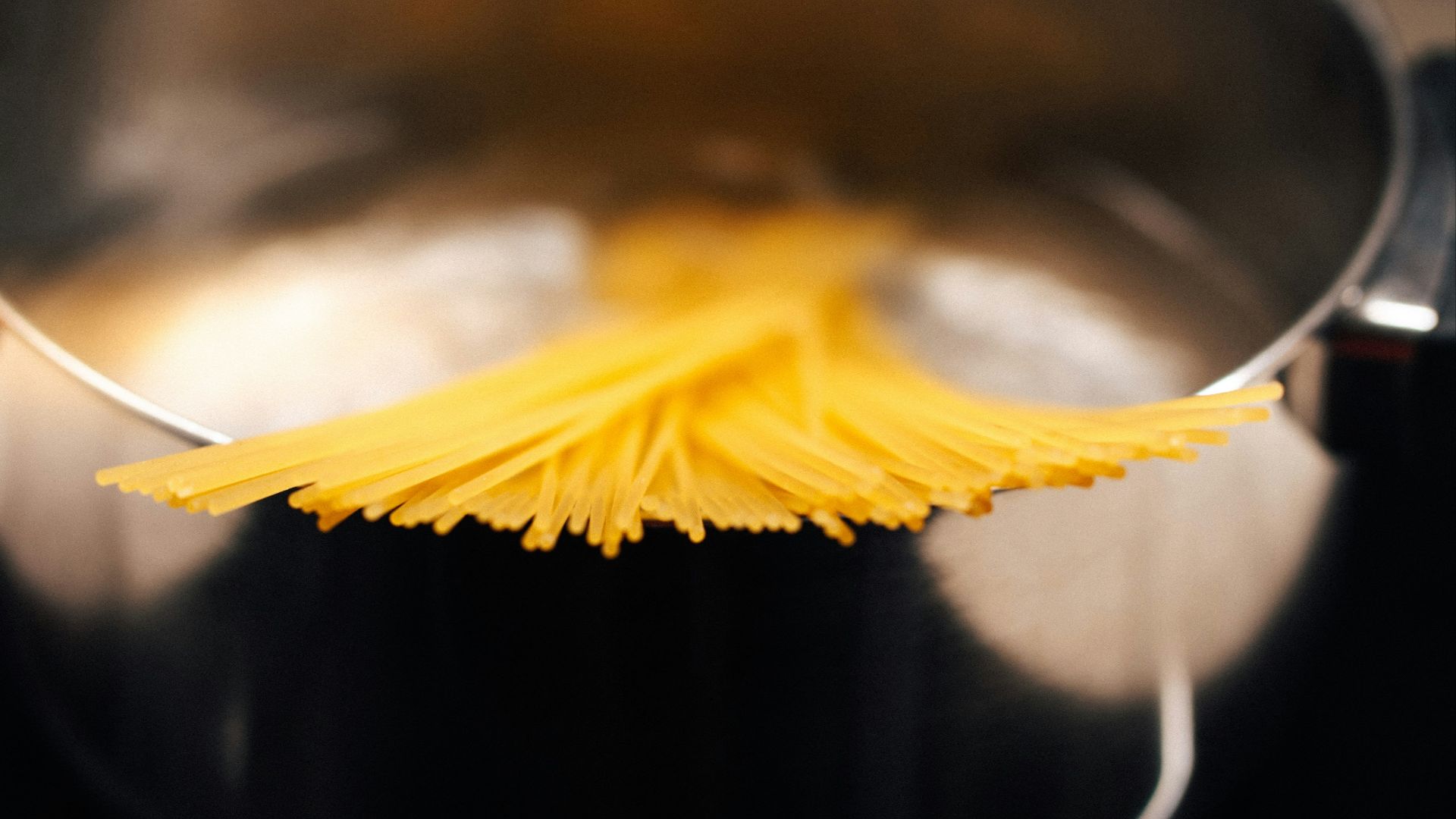 a close up of a metal pot with noodles in it