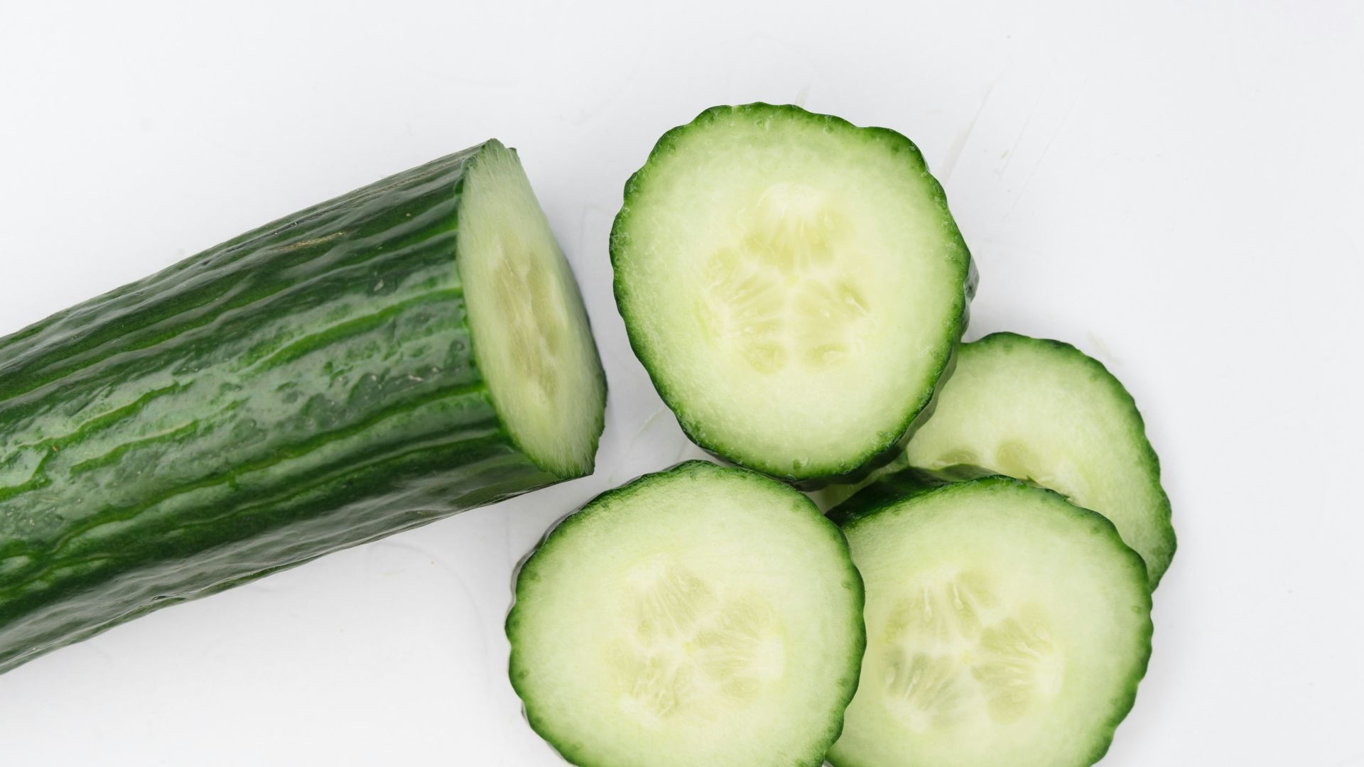 sliced cucumber on white surface