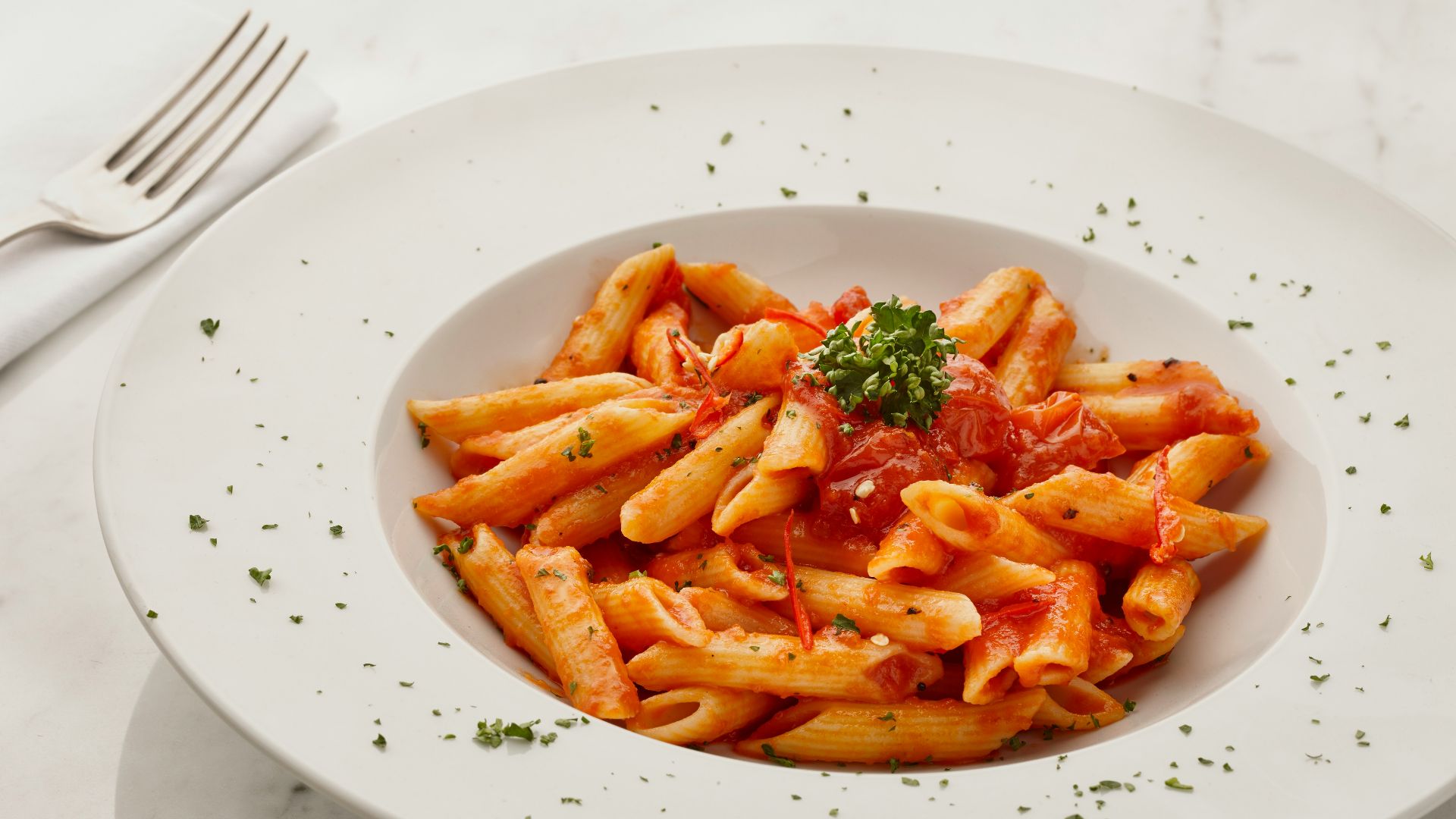 a white plate topped with pasta covered in sauce