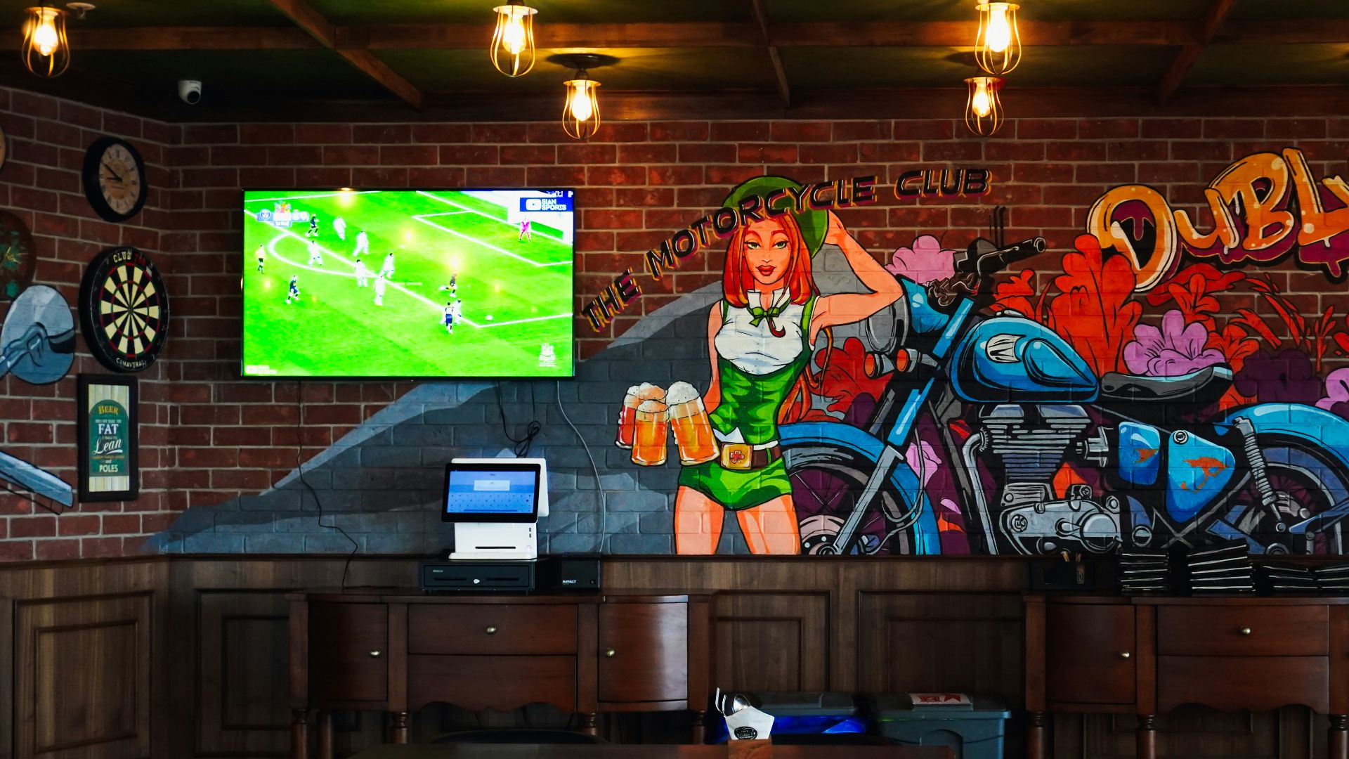 Irish pub interior with motorcycle mural and television.