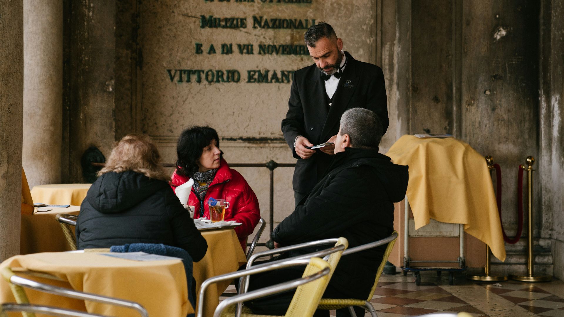 man in black suit sitting on white chair