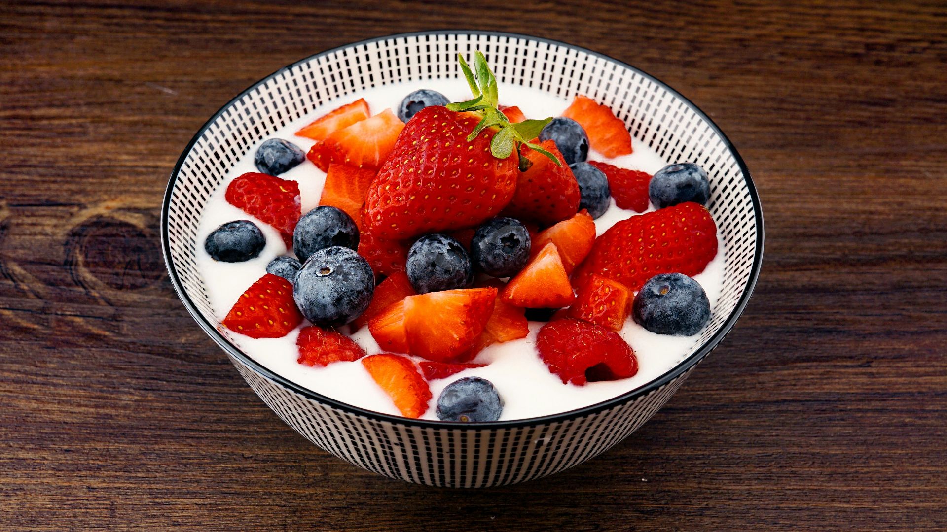 strawberry and blackberries on top of brown table