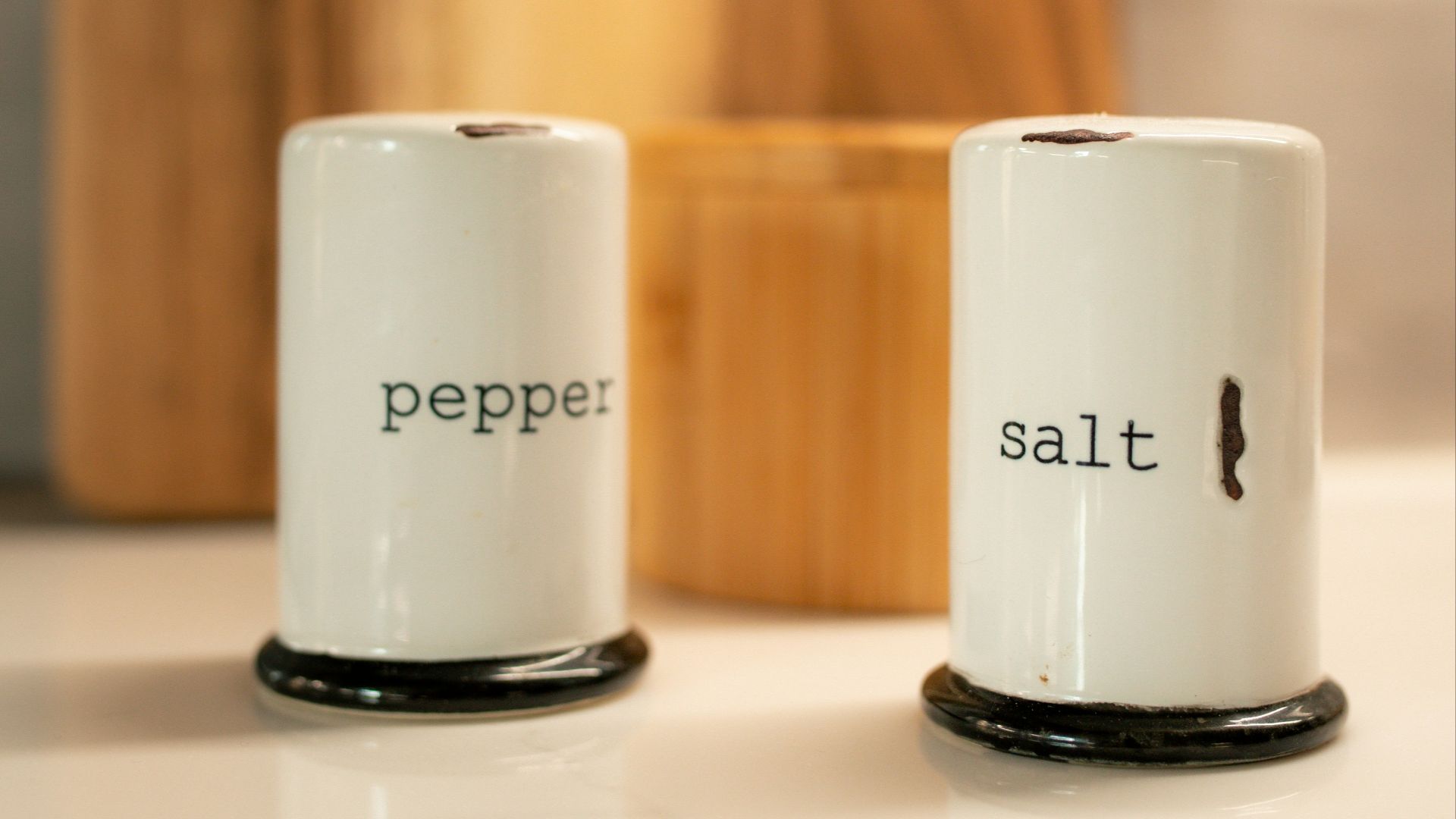 two salt and pepper shakers sitting on a counter