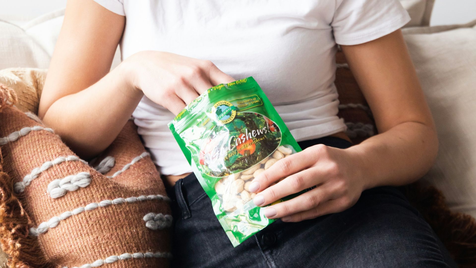 woman in white crew neck t-shirt holding green plastic pack