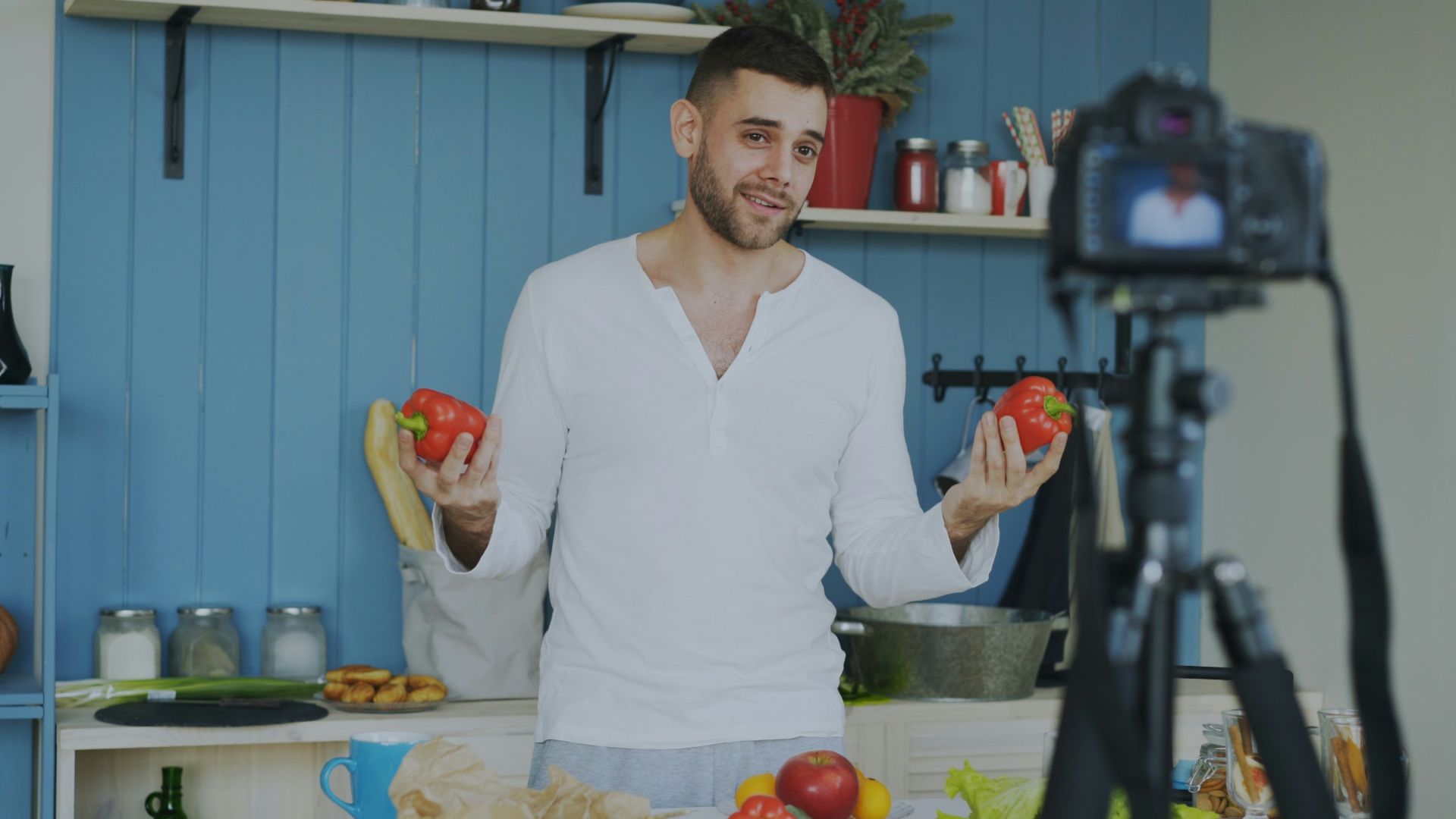 Man holding tomatoes in a kitchen