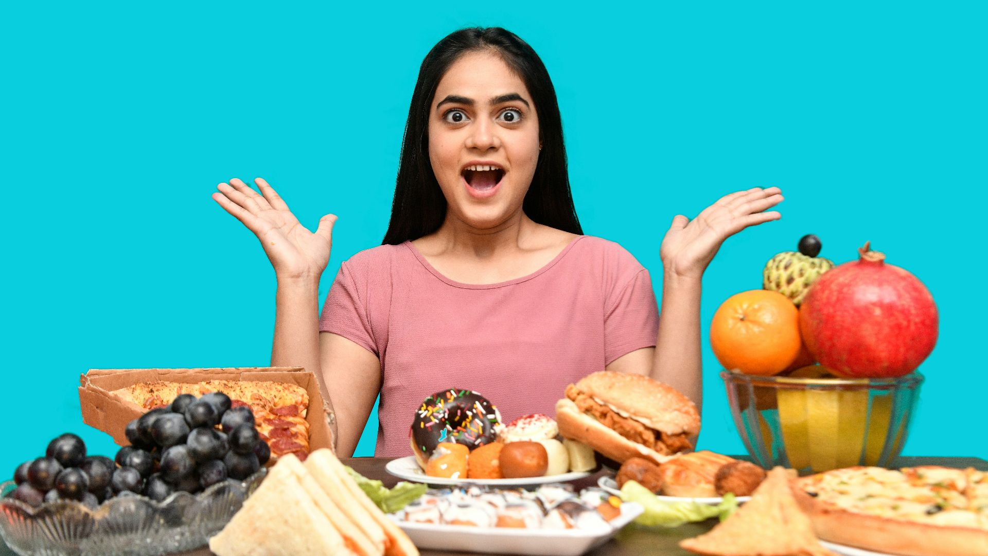 a woman with her mouth open and hands up in front of a table of food