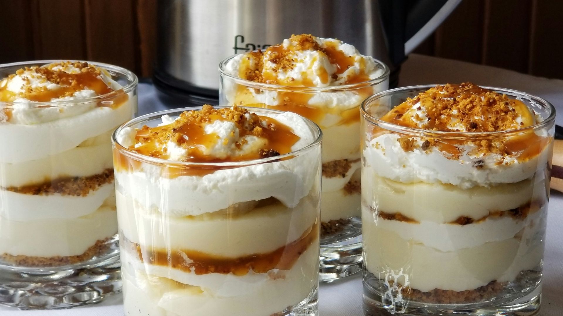 four desserts sitting on a table with a crock pot in the background