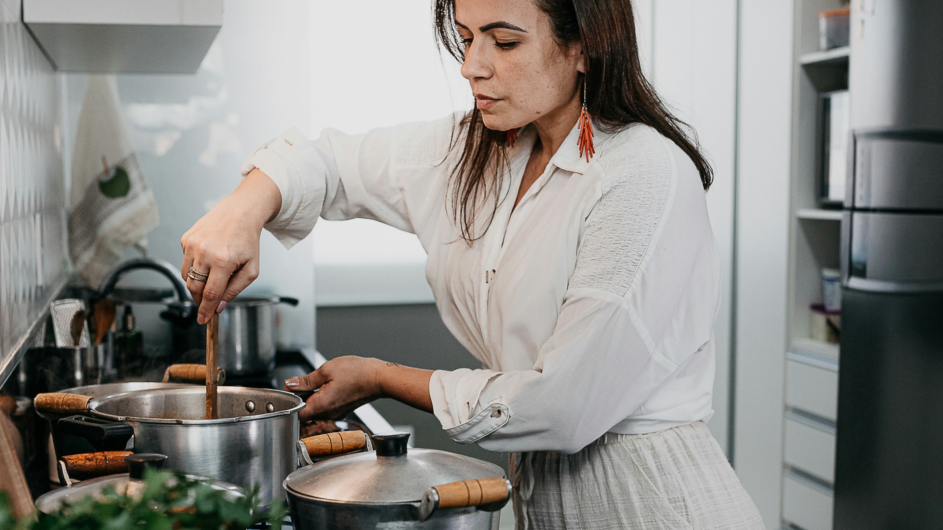 woman in white long sleeve shirt holding green vegetable