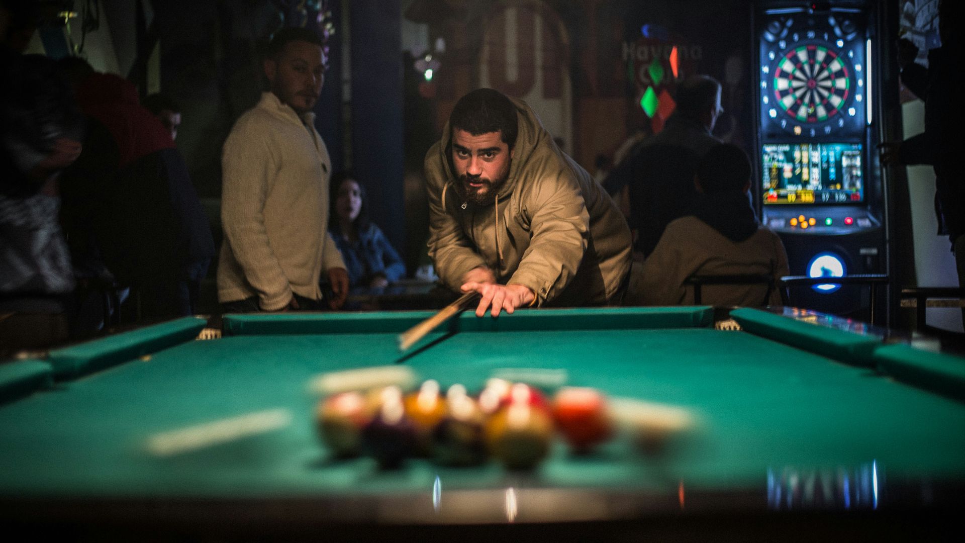 man in brown jacket playing billiard