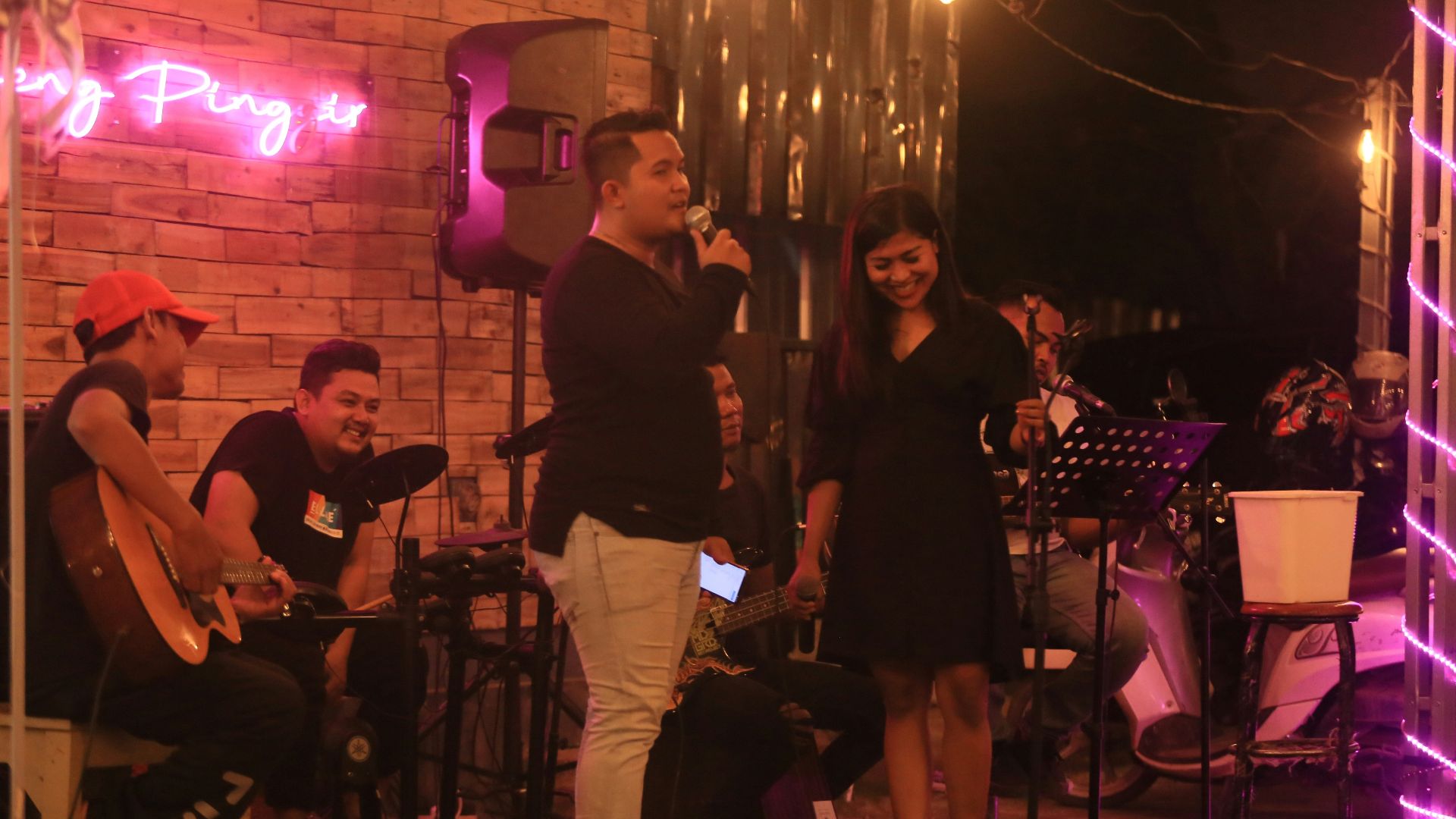 A band performs music for an audience at night.