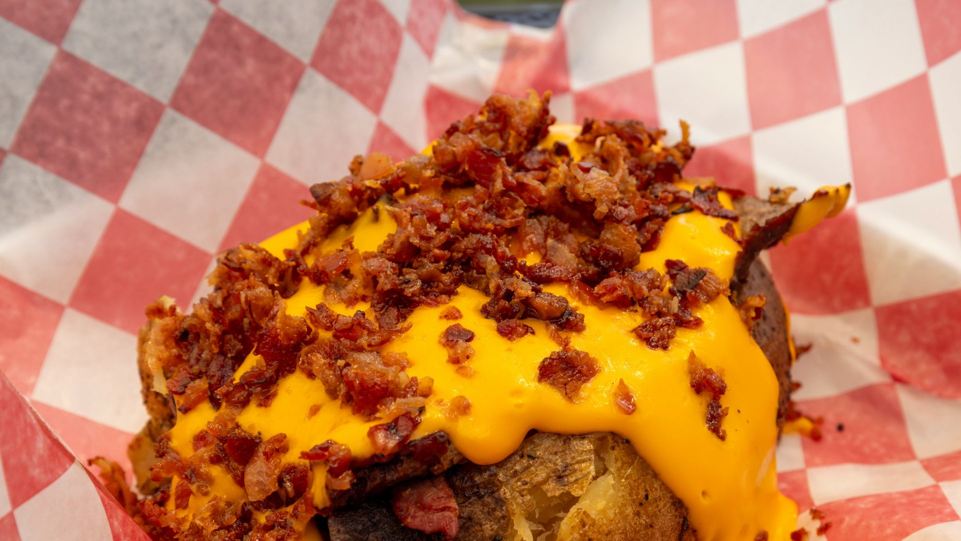 Baked potato with melted cheese and bacon bits