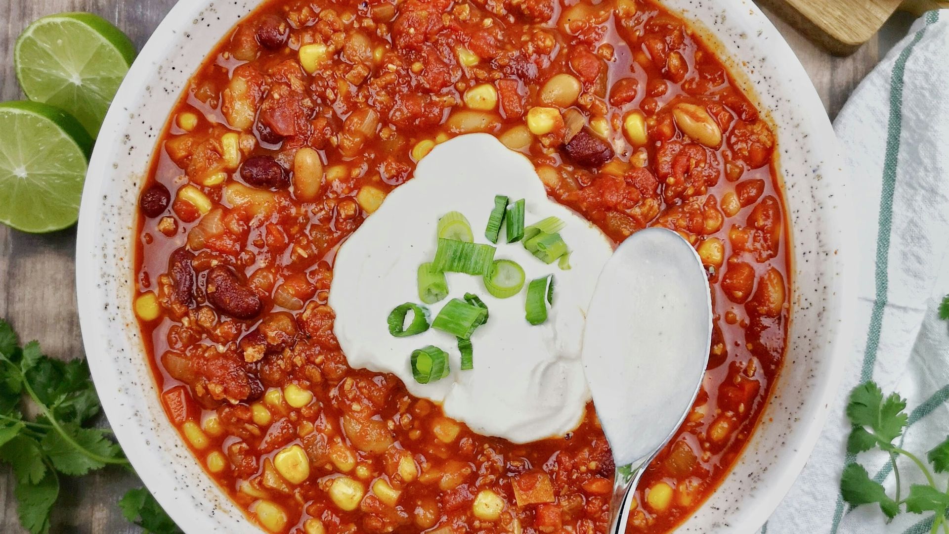 a bowl of chili with sour cream on top