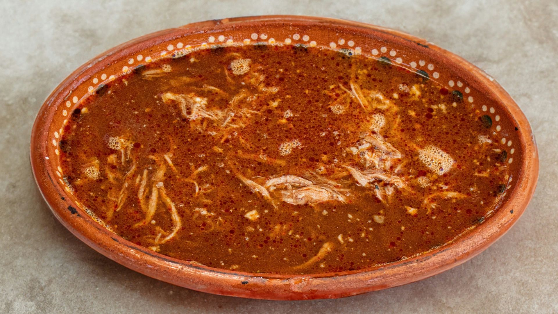 A small orange bowl sitting on top of a table