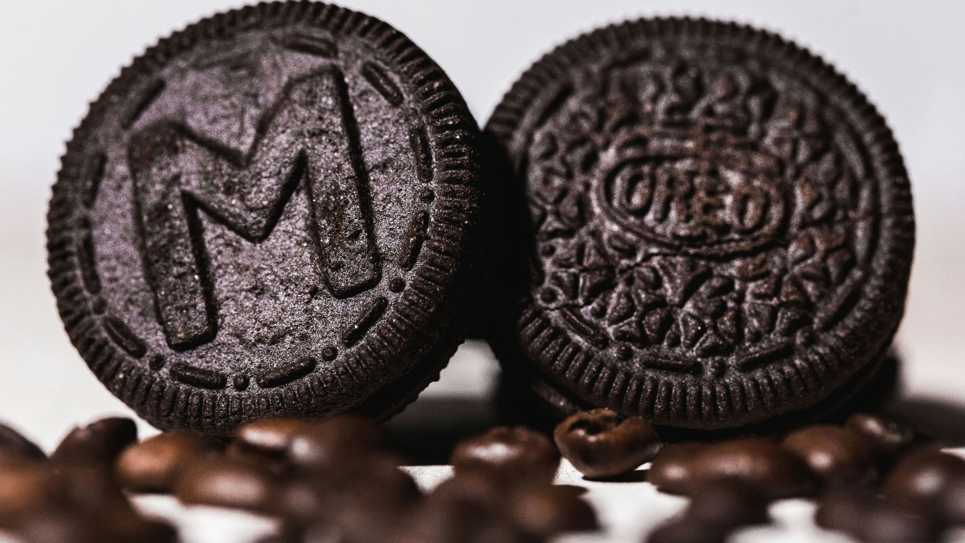 two oreos sitting on top of a pile of coffee beans