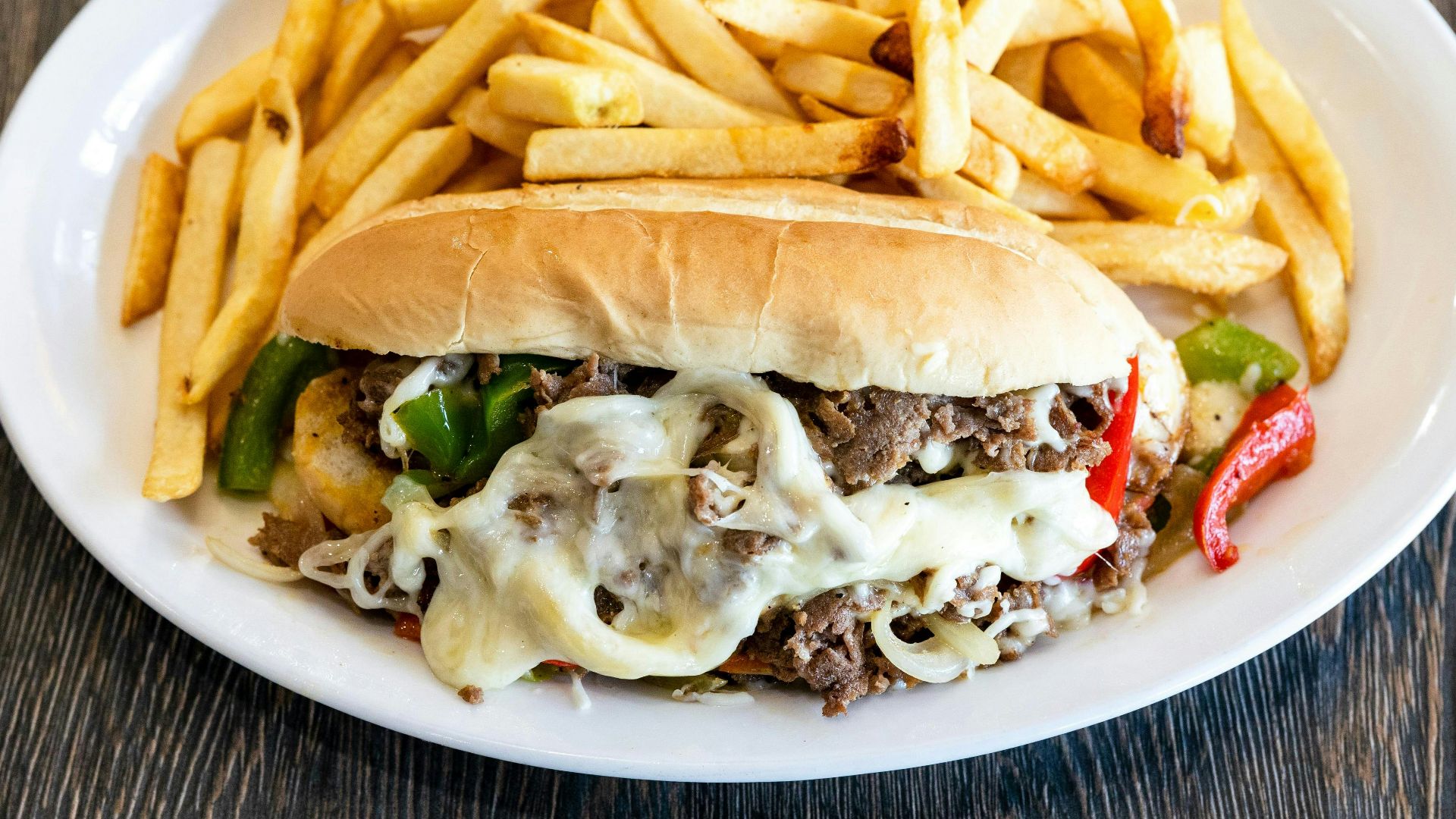 A white plate topped with a sandwich and fries