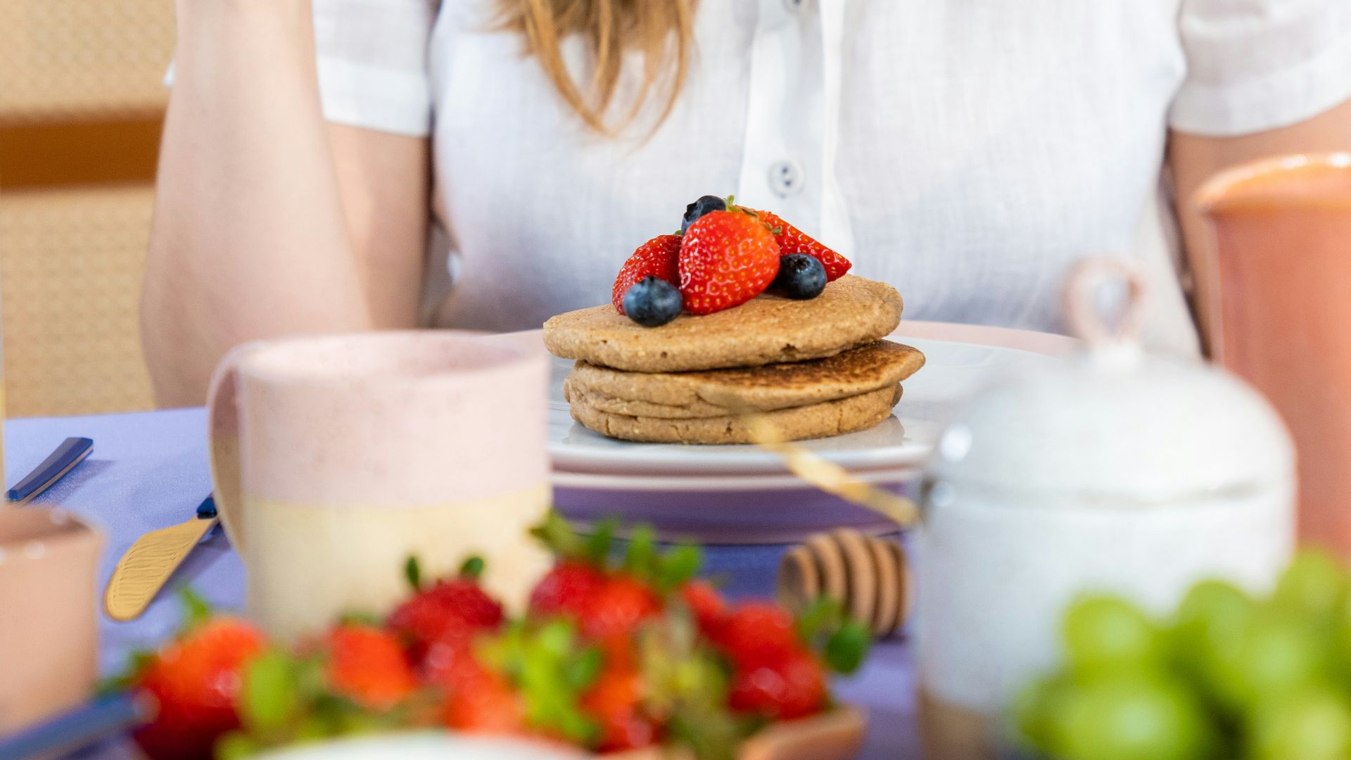 a woman sitting at a table with a plate of food