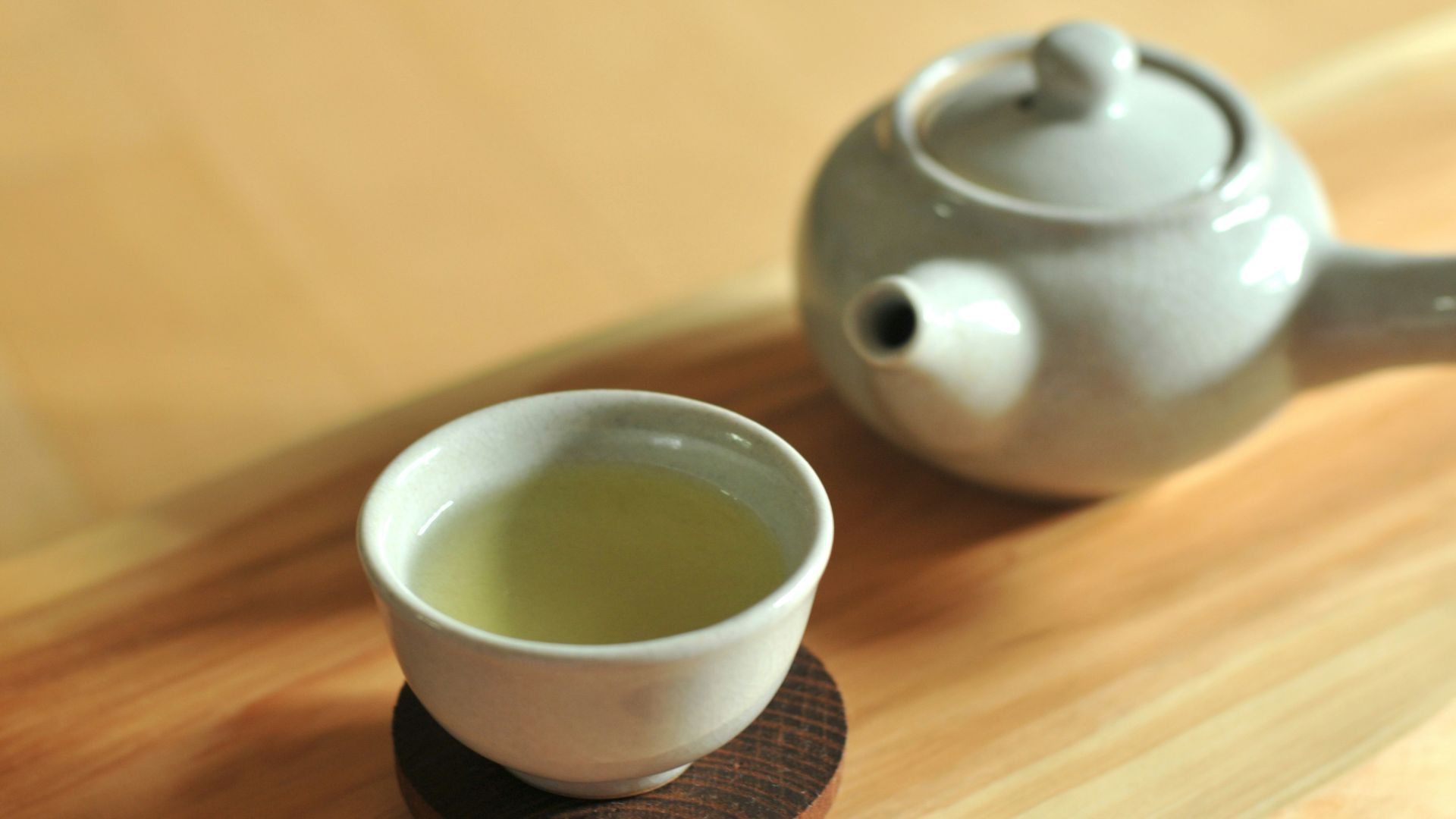 white ceramic teacup on brown wooden table