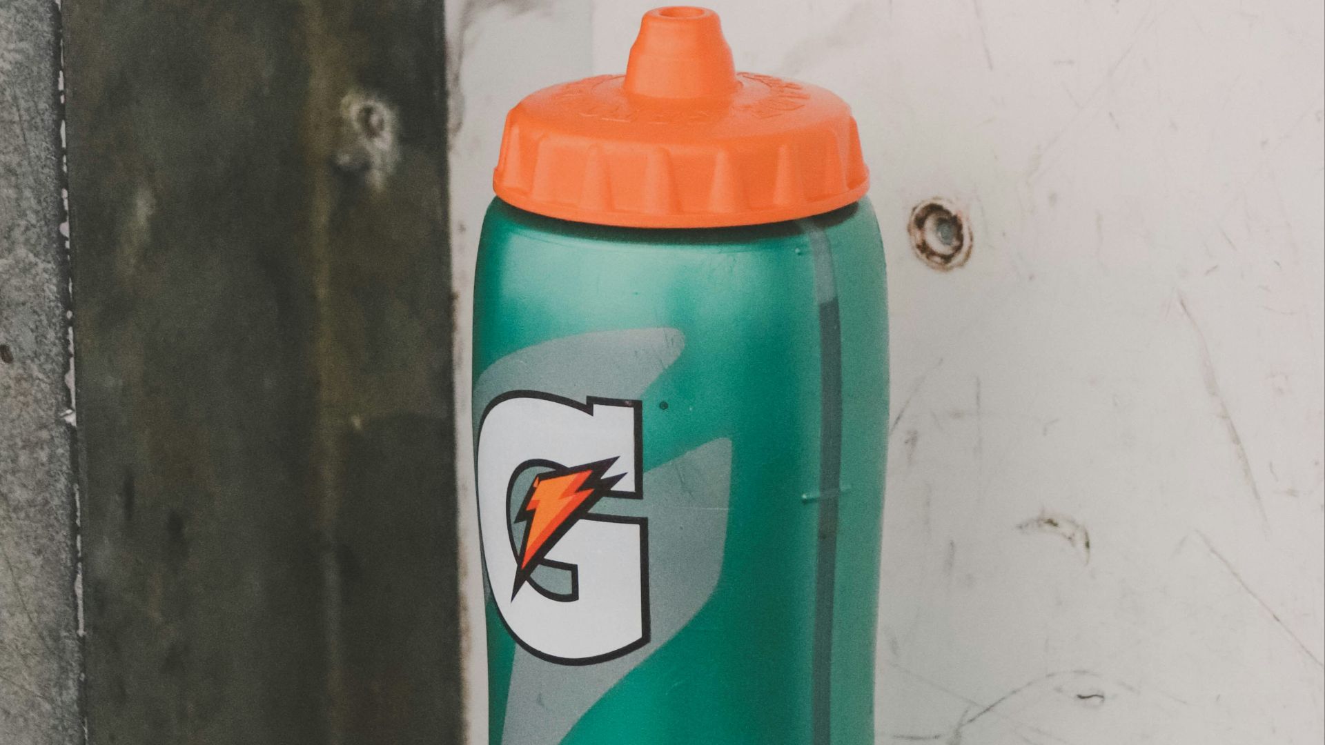 a green sports bottle sitting on top of a blue mat