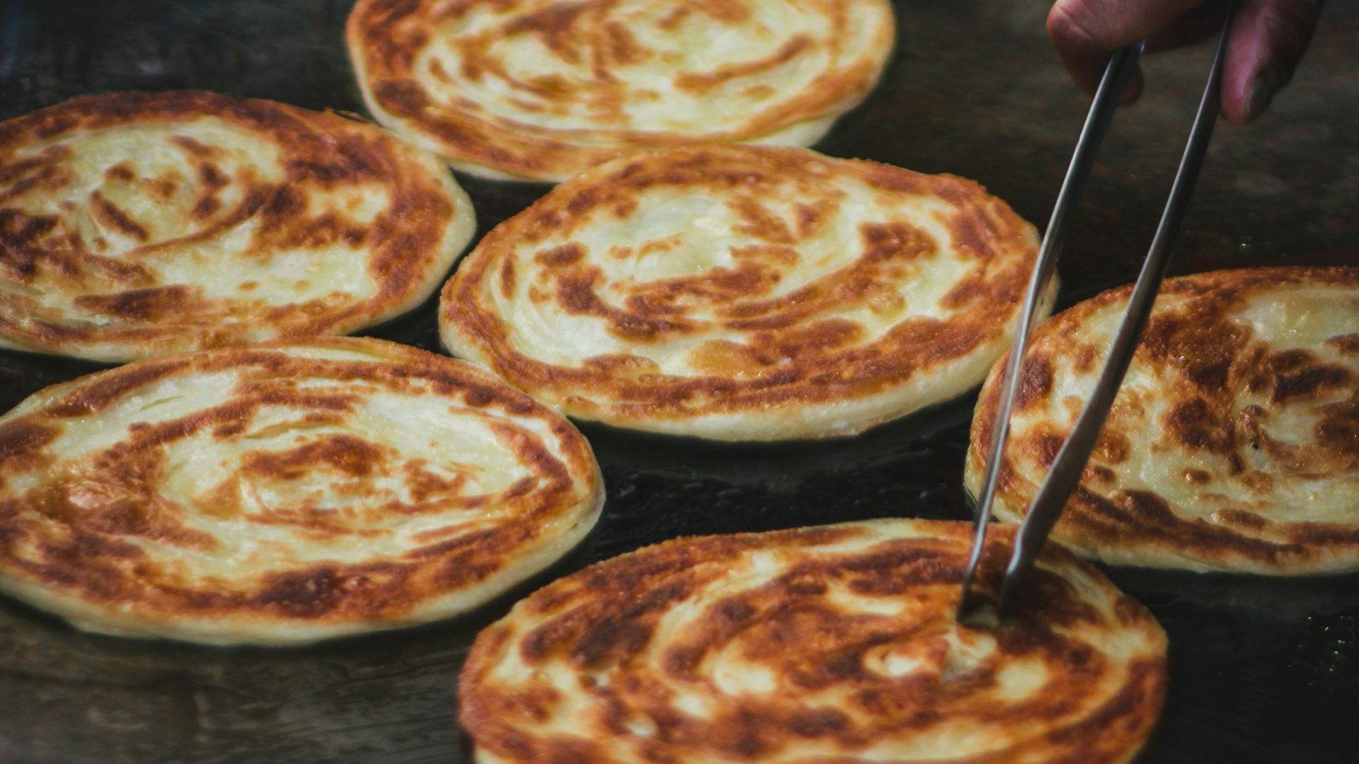 a person slicing a pizza