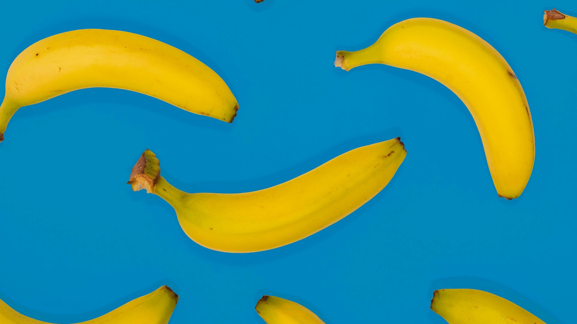 yellow banana fruits on blue surface
