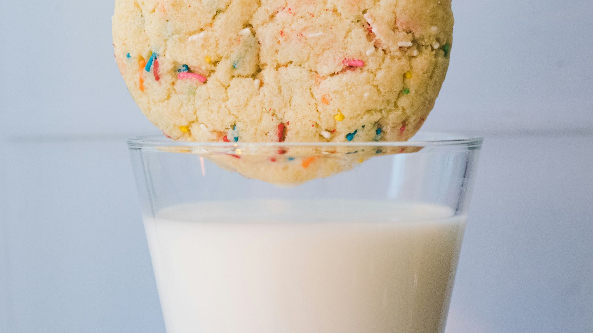 a cookie on top of a glass of milk