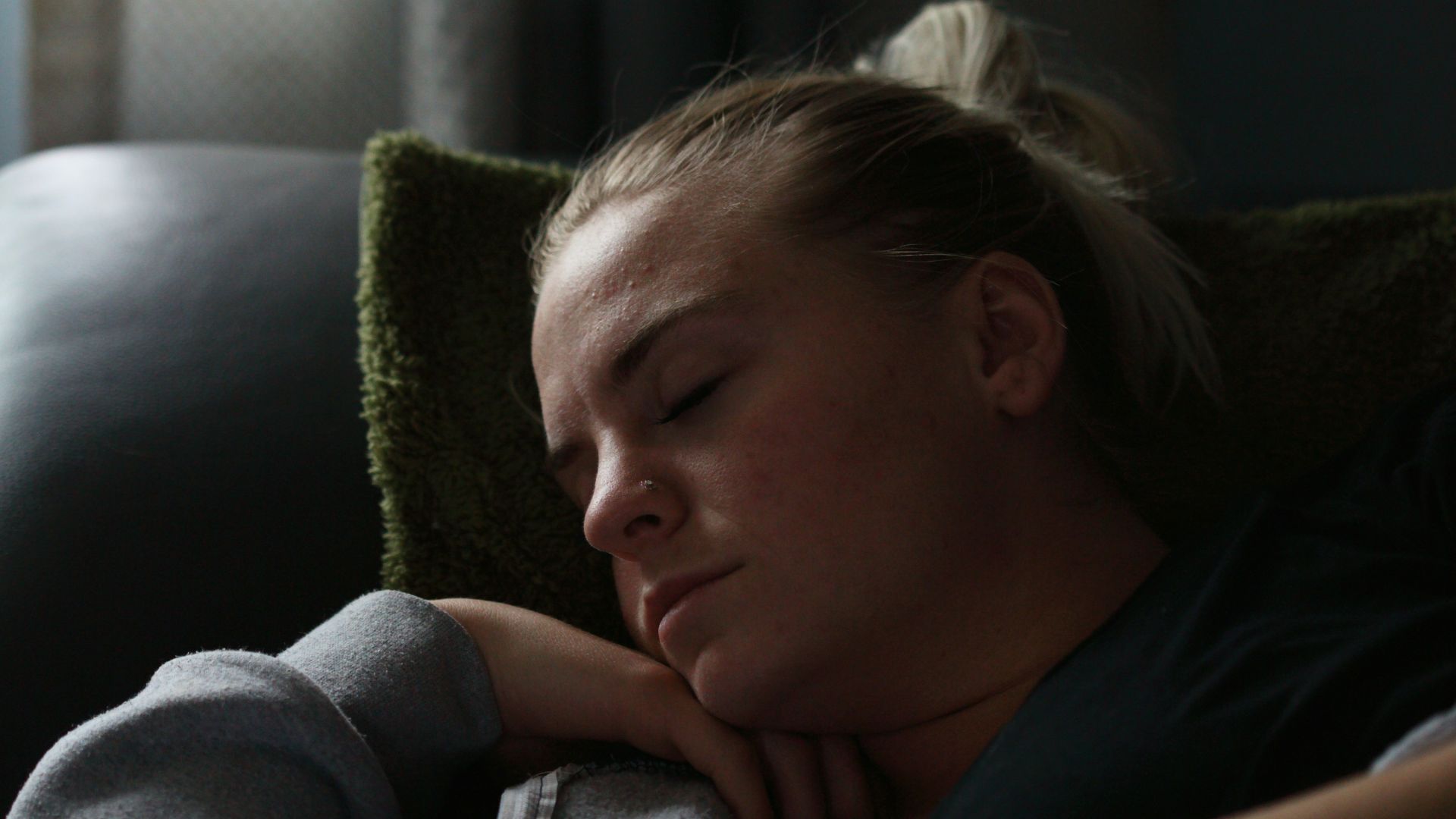 woman in black shirt lying on couch