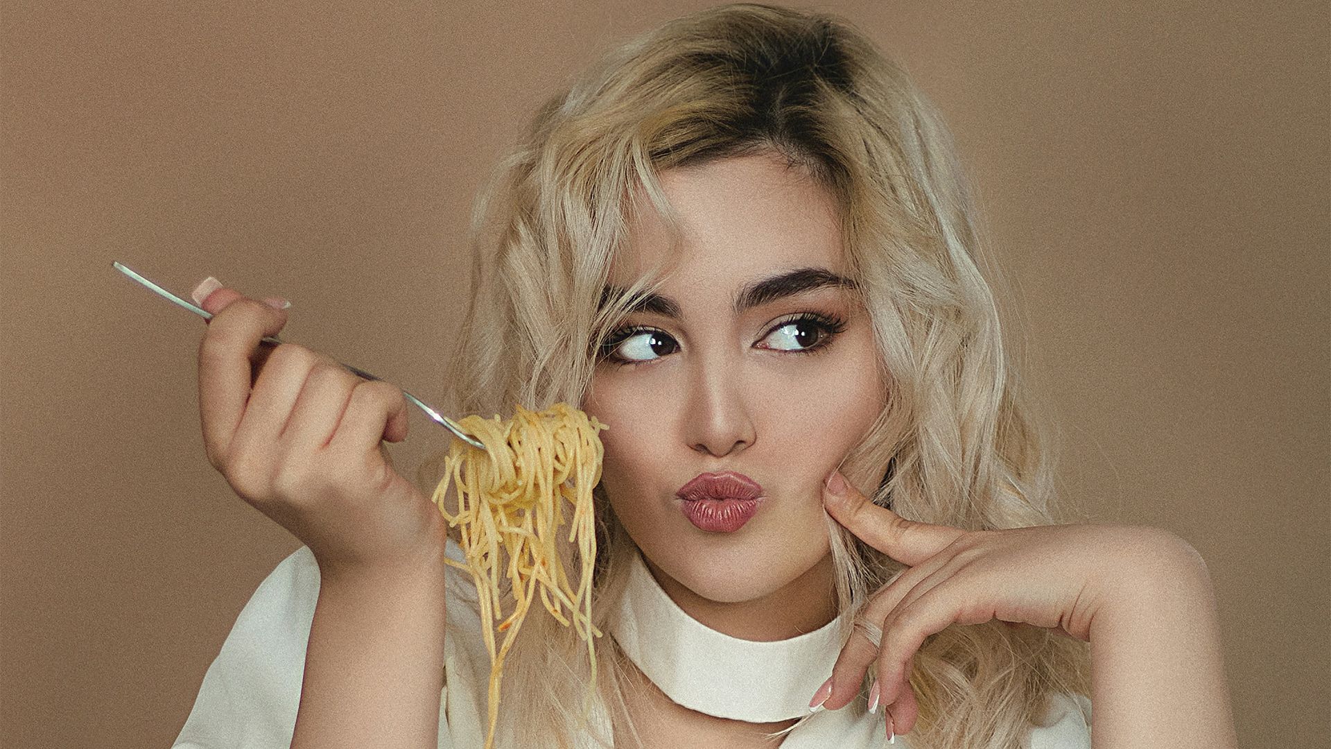 woman in white dress shirt holding sliced pizza