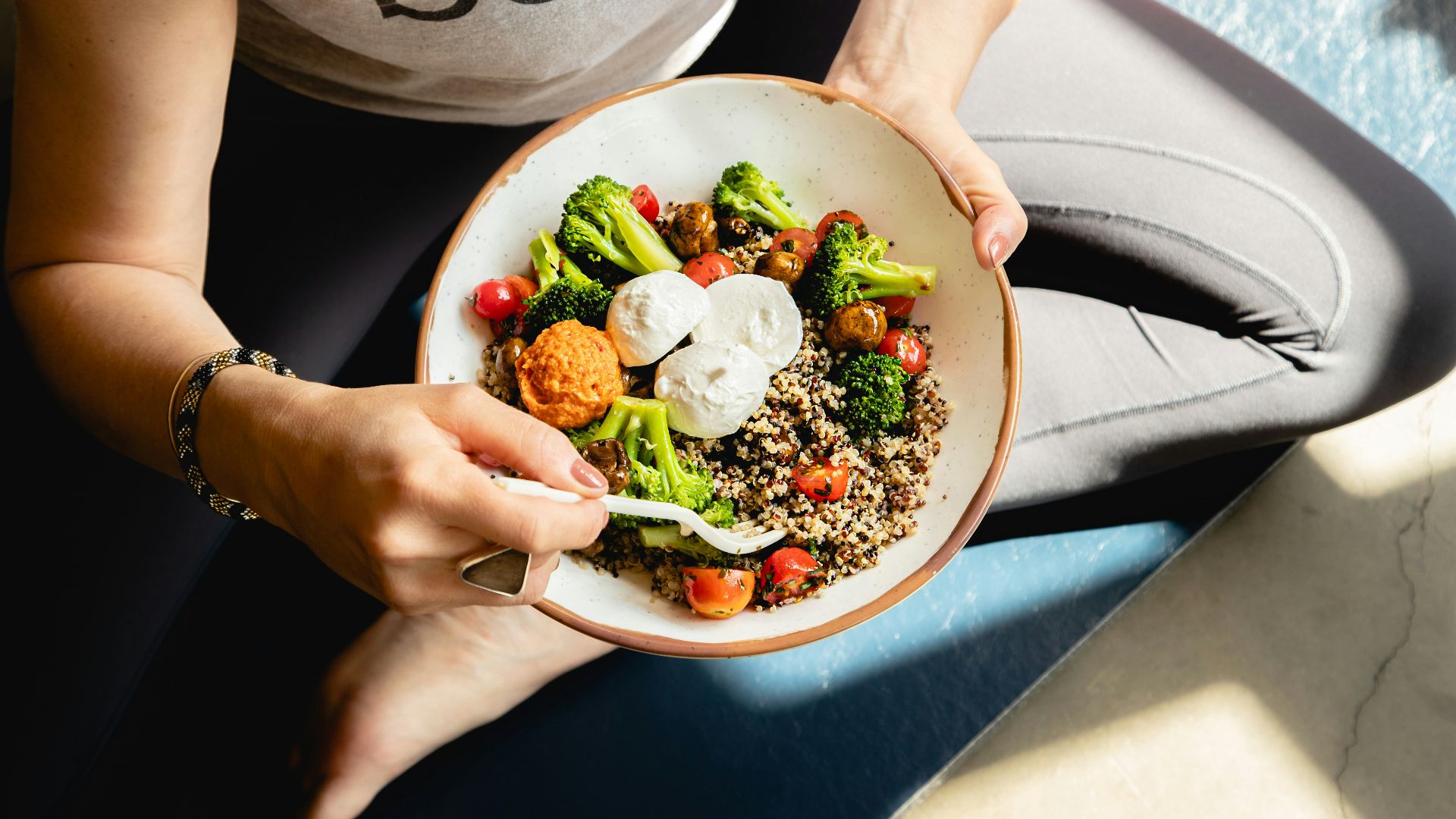 a woman is holding a bowl of food